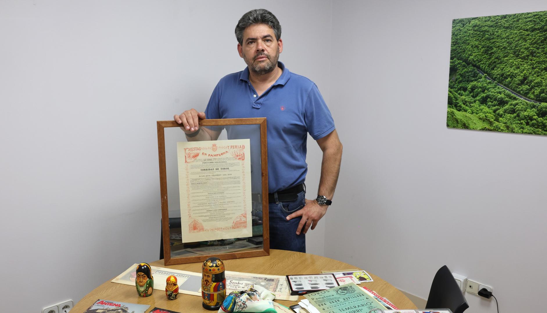 El coleccionista Javier Azqueta Rodríguez rodeado por algunas de sus piezas. En sus manos, sujeta el programa de San Fermín de 1880 ―único ejemplar, por ahora, documentado―
