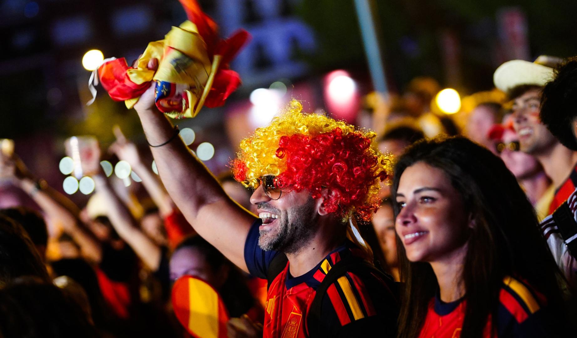 Aficionados celebran la victoria de España en las semifinales del Mundial 2026 que han disputado frente a Francia, desde la "fan zone" de la Plaza de Colón en Madrid, este martes