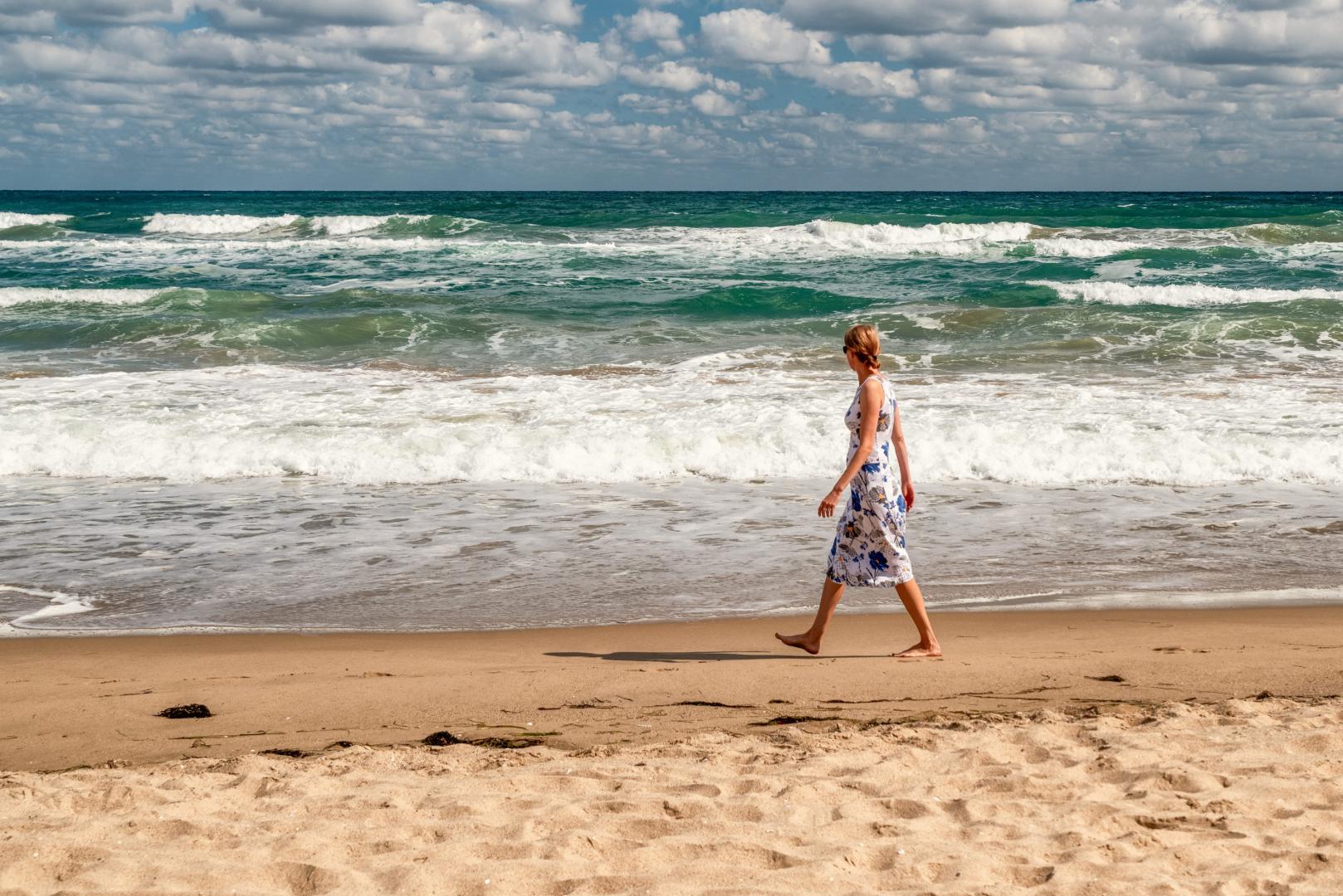 Una mujer da un paseo por la playa