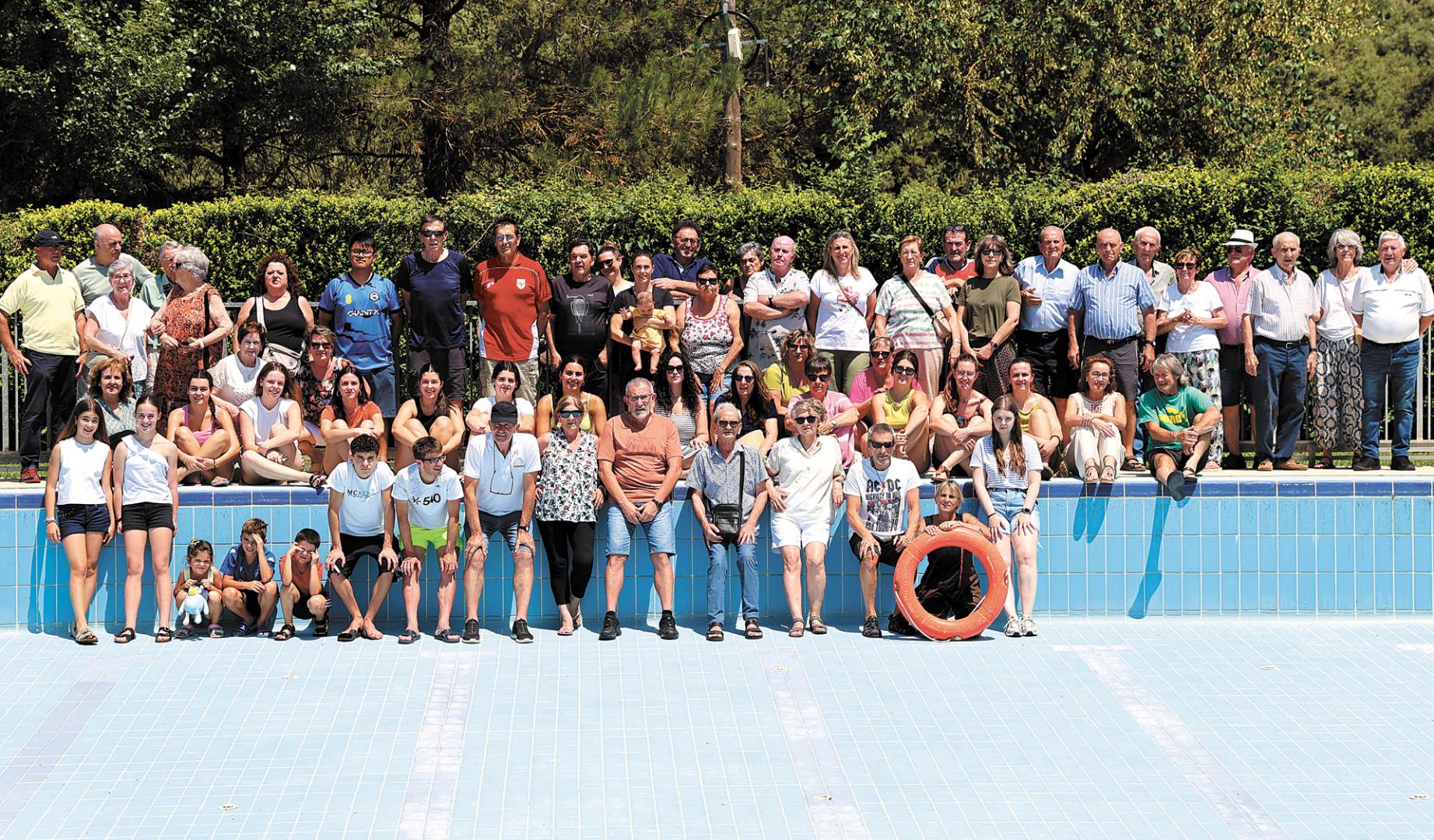 Vecinos de distintas generaciones posan en la piscina de su pueblo, Igúzquiza, vacía para su pesar este verano