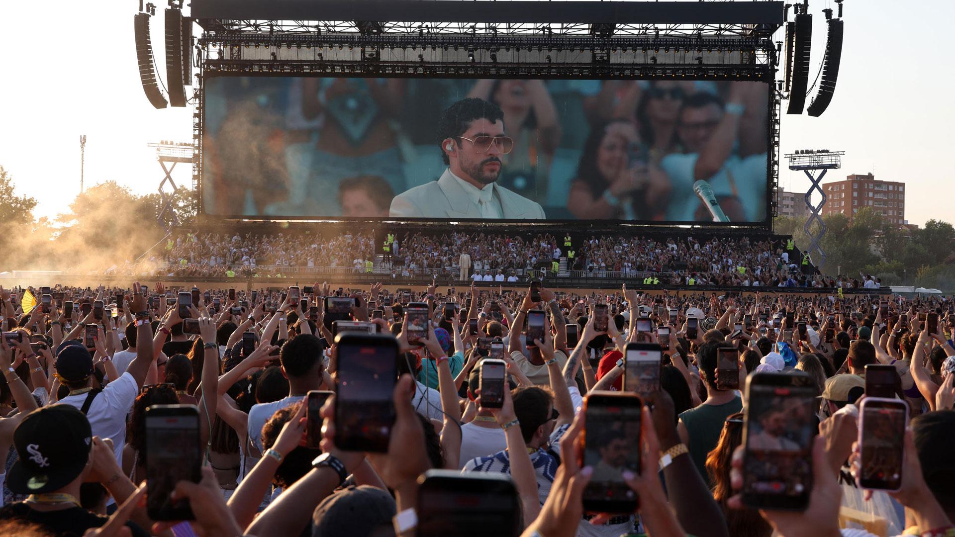 Miles de personas enfocan con sus móviles a Bad Bunny en el comienzo de su concierto en Milán que tuvo que ser anulado por un fuerte temporal de lluvia y granizo