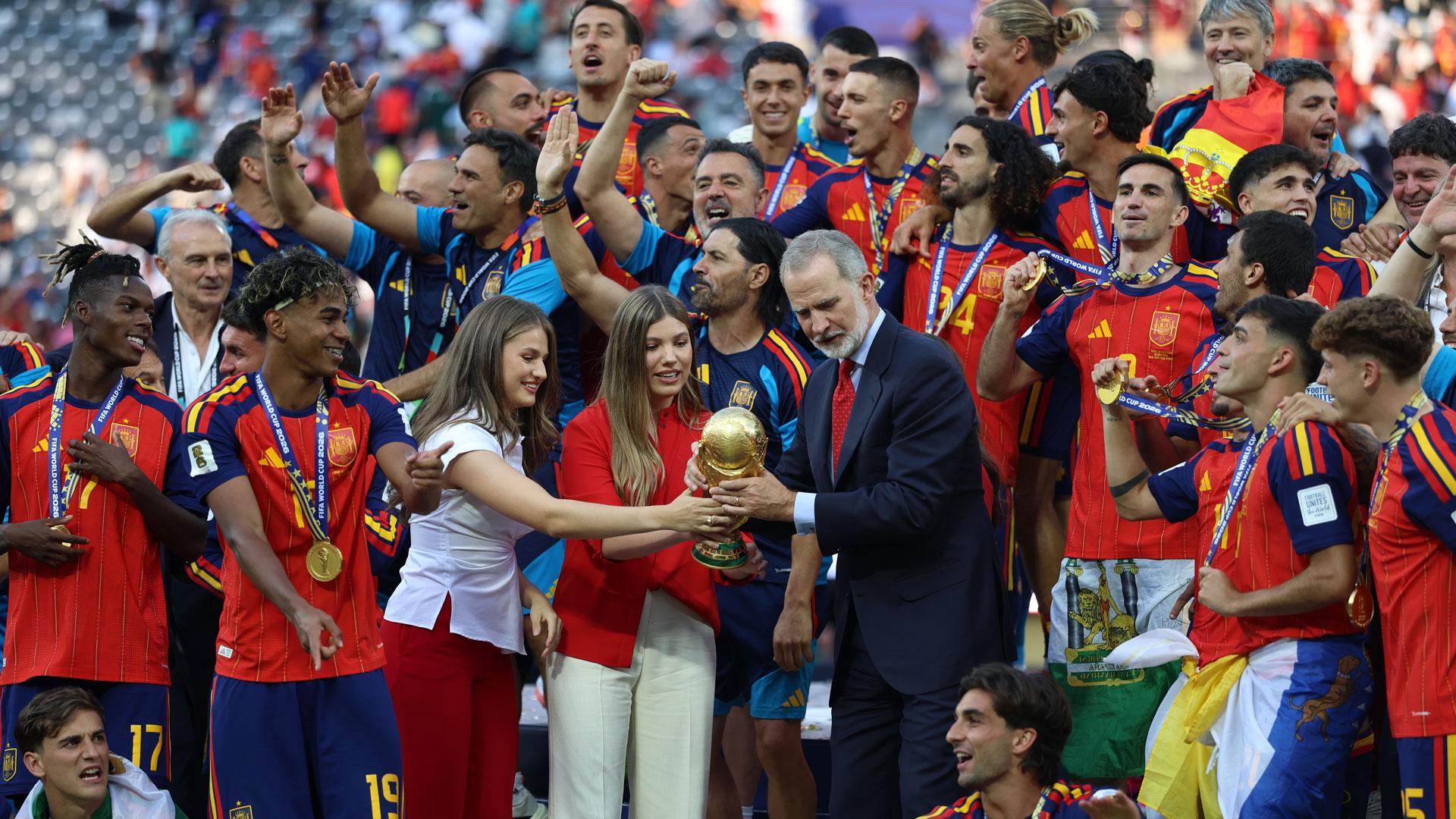 El rey Felipe VI, la princesa Leonor y la infanta Sofía, acompañados de los jugadores de España celebran en el podio con el trofeo de campeones del mundo