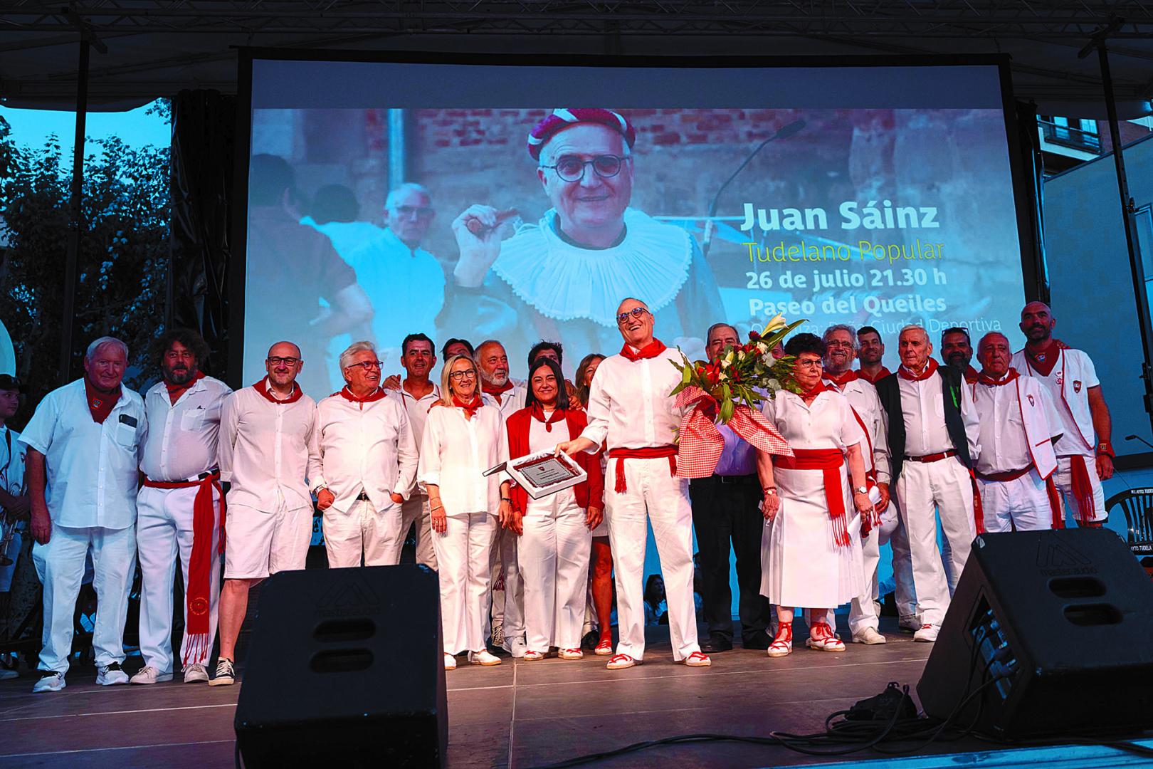 Juan Sáinz, sosteniendo un ramo de flores, junto a anteriores Tudelanos Populares durante su homenaje en el paseo del Queiles