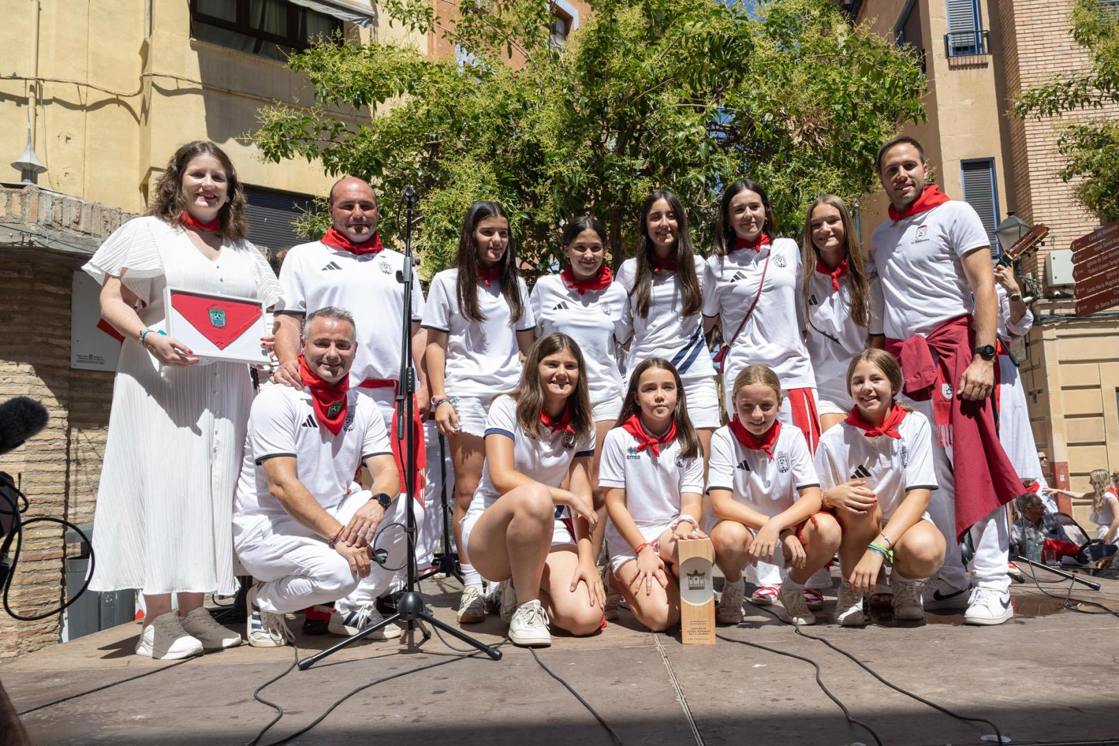 Miembros y jugadoras del C.D. Lourdes, junto a peñistas de La Revolvedera durante el homenaje