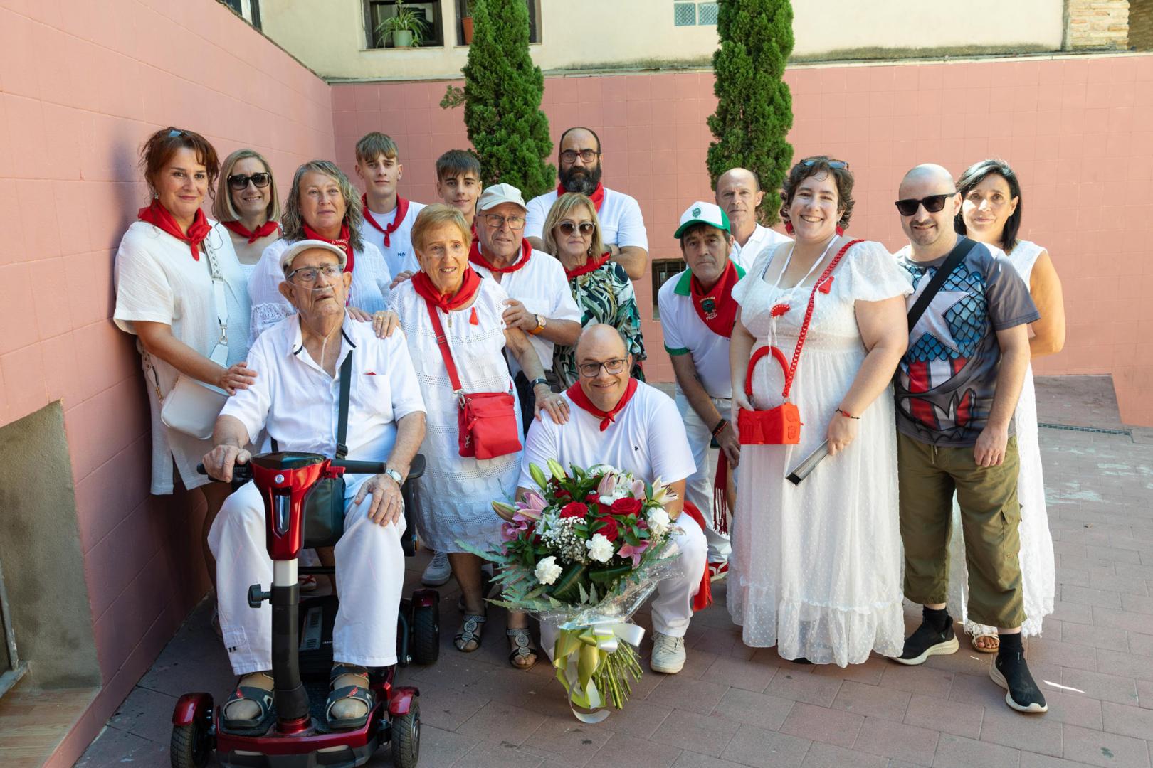 Mª Carmen Pérez Casas, en el centro del grupo con bolso rojo, junto a sus familiares y miembros de la peña Moskera