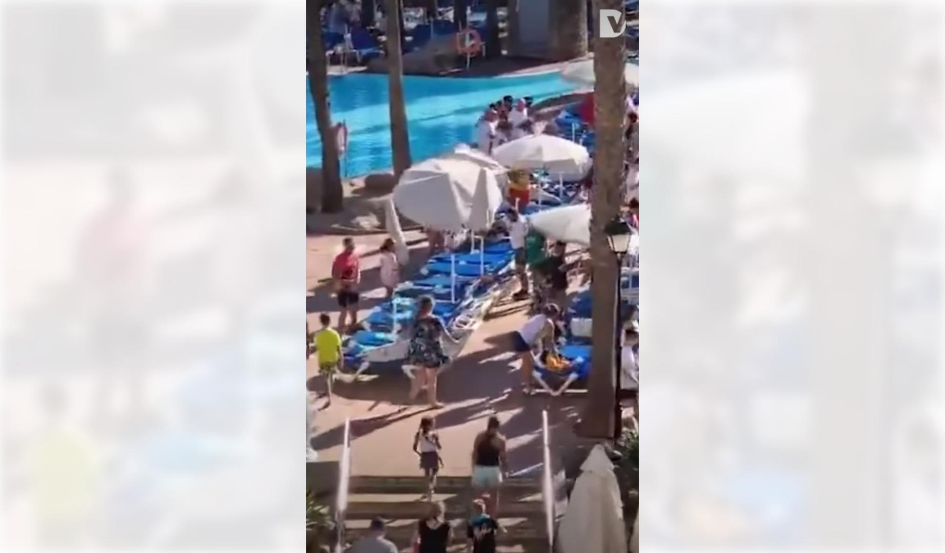 Los turistas celebrando conseguir la hamaca en la piscina del hotel