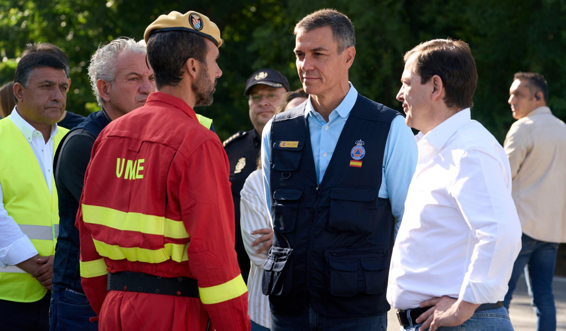 El presidente del Gobierno, Pedro Sánchez (c), el presidente de la Junta de Castilla y León, Alfonso Fernández Mañueco (d) y el delegado del Gobierno en esta comunidad, Nicanor Sen (2i), conversan con un miembro de la Unidad Militar de Emergencias (UME) durante su visita este jueves al Puesto de Mando Avanzado del incendio de Burgohondo instalado en la localidad abulense de Navaluenga.