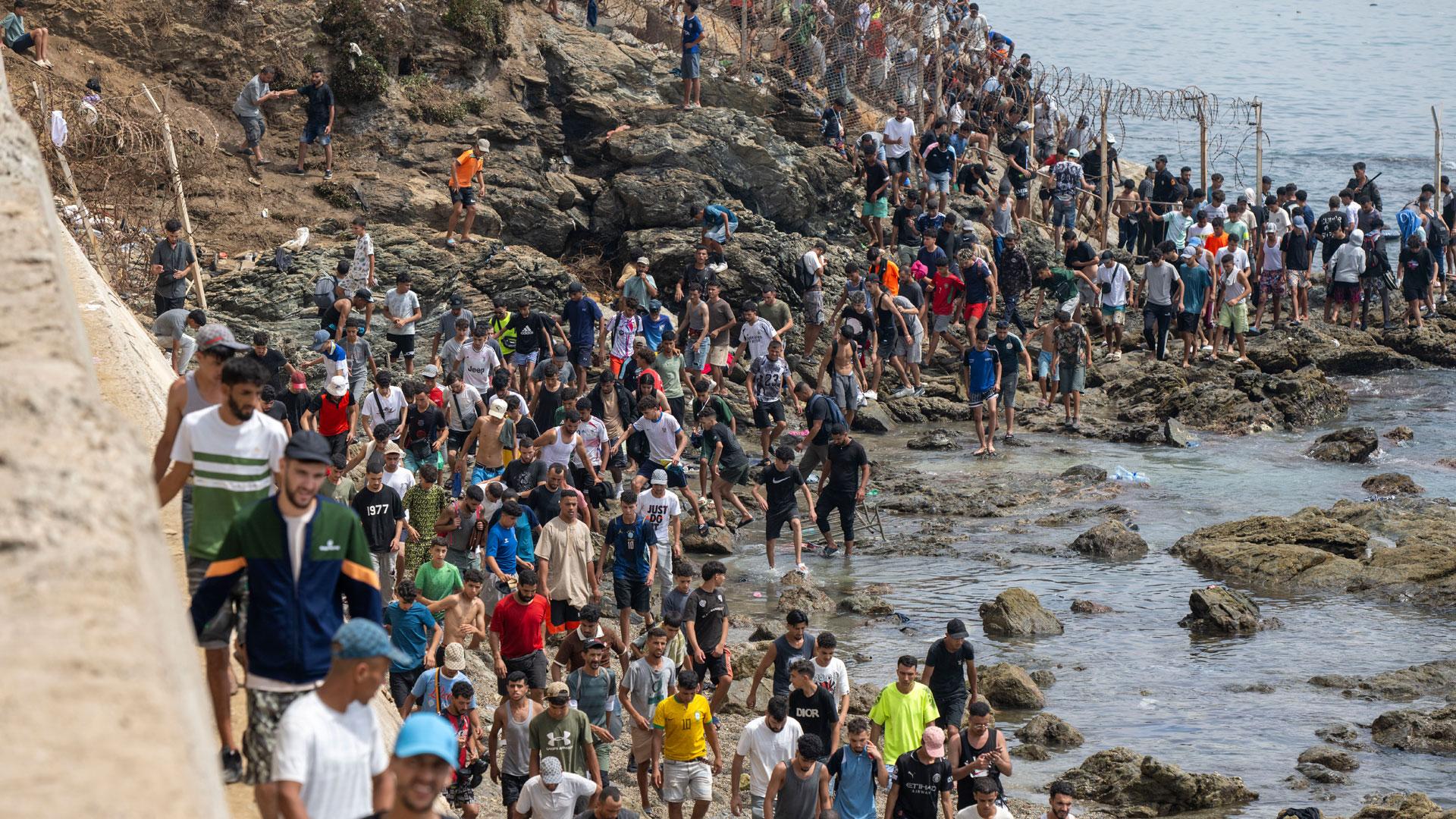 Jóvenes regresan a Marruecos por el mar en el paso fronterizo de Bab Sebta, tras haber protagonizado una entrada masiva irregular a Ceuta