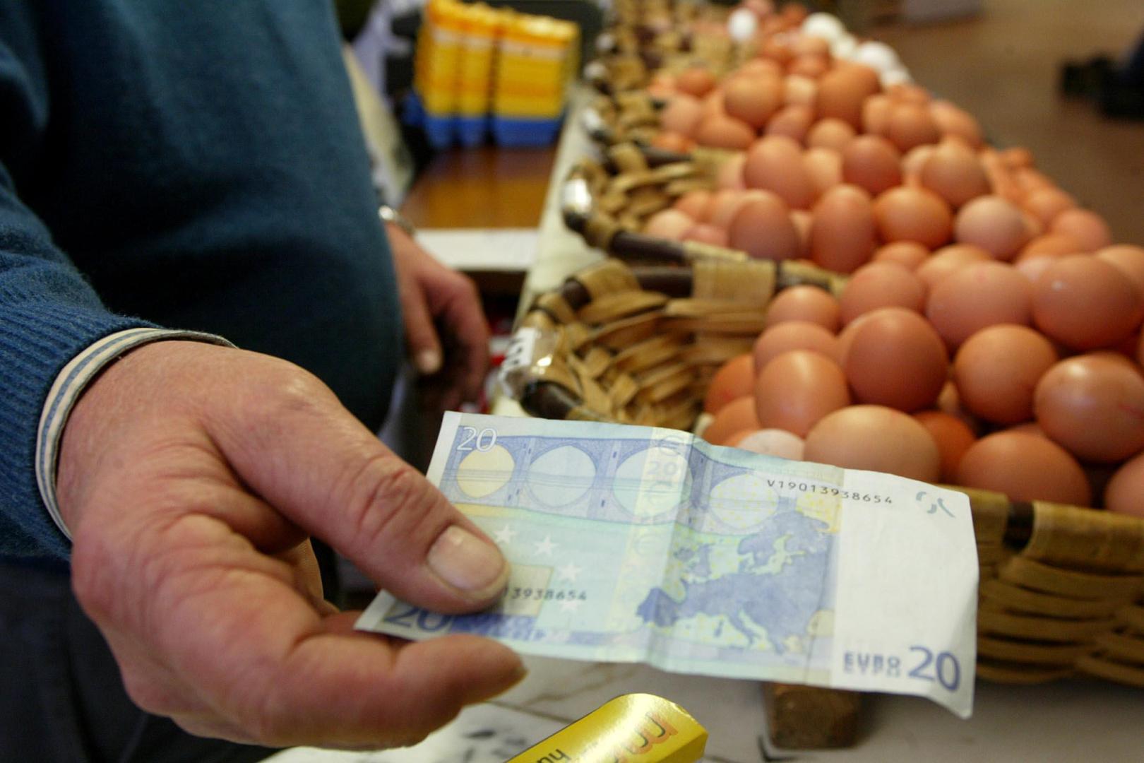 Una persona saca un billete de 20 euros para comprar huevos