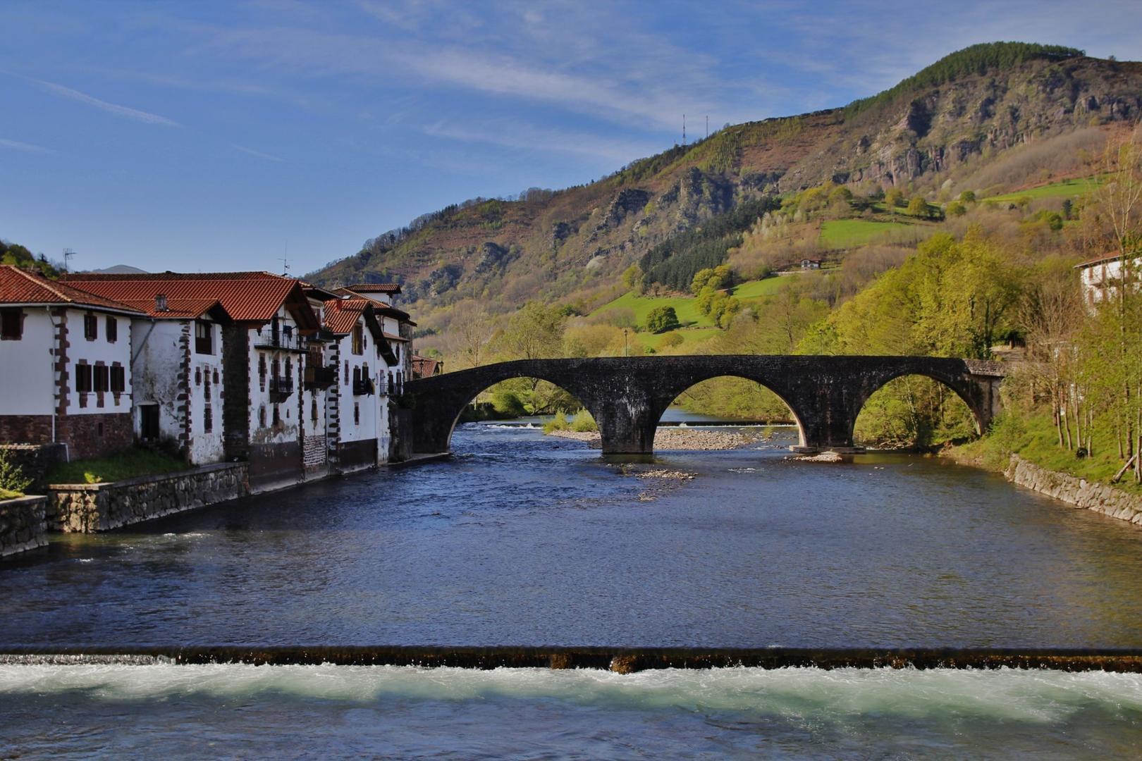 En primer término, tubería que cruza el río en Sunbilla. Detrás, el puente viejo, y al fondo el azud de Jorajuria que desaparecerá. Foto de 2014