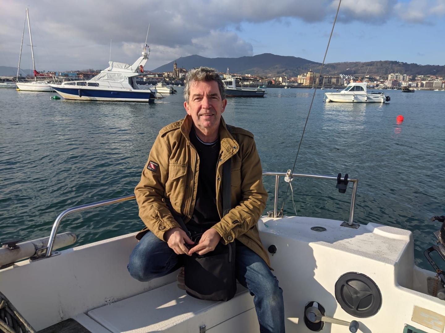 Alfredo Piedrafita sonríe subido a un barco en la bahía de Txingudi, entre Hendaya, Hondarribia e Irún.