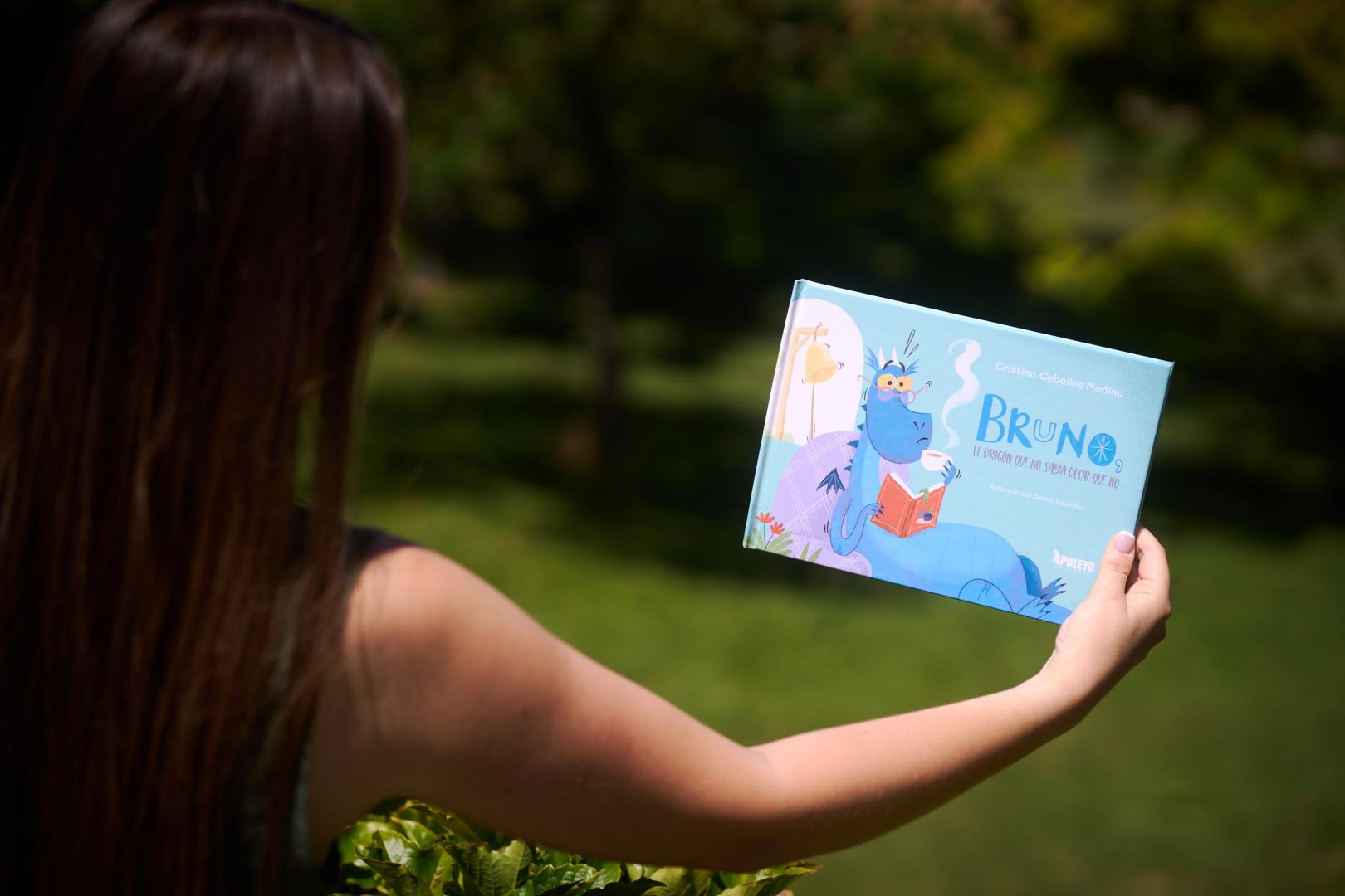 La autora de ‘Bruno, el dragón que no sabía decir que no’ muestra la portada de su libro