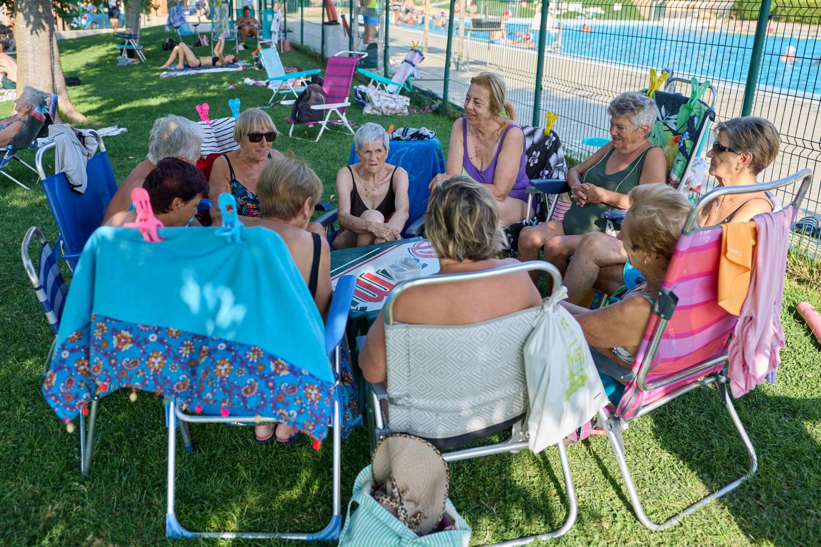Diez vecinas de Puente, fieles a su cita vespertina en la piscina en torno a las cartas.