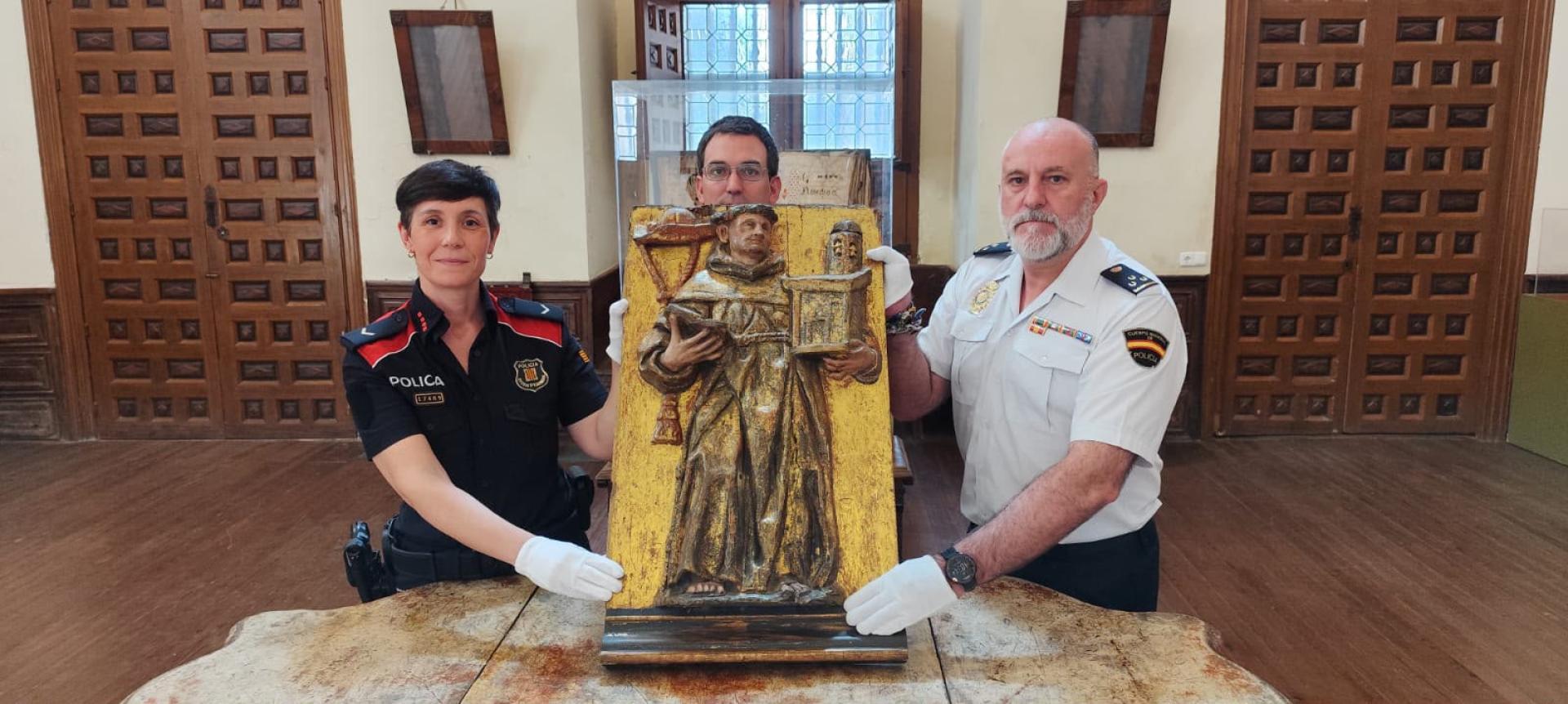 Representantes de Policía Nacional y Mossos d´Esquadra entregan al párroco de Fitero el relieve robado hace 16 años.