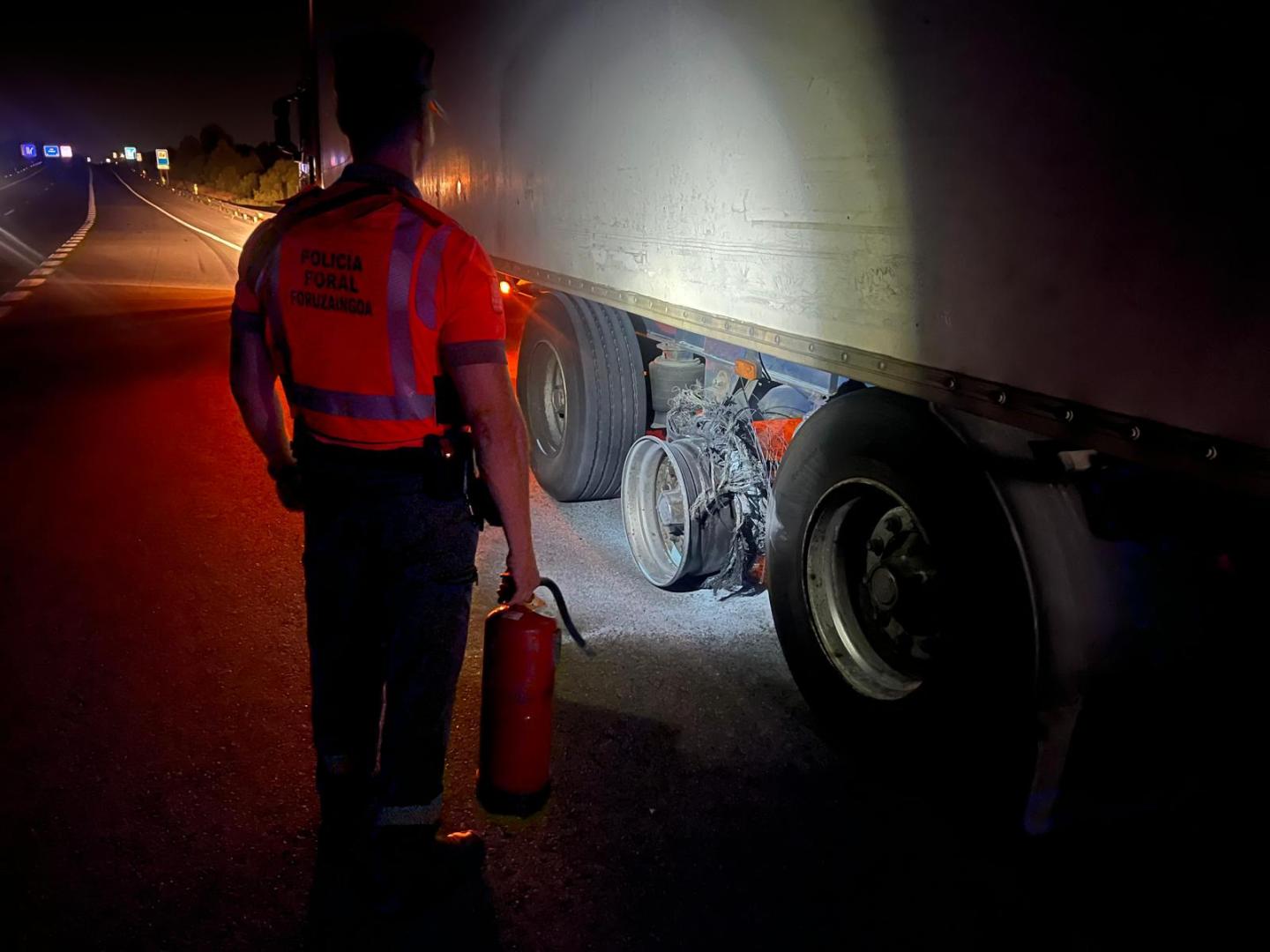 Uno de los agentes junto al camión y un extintor