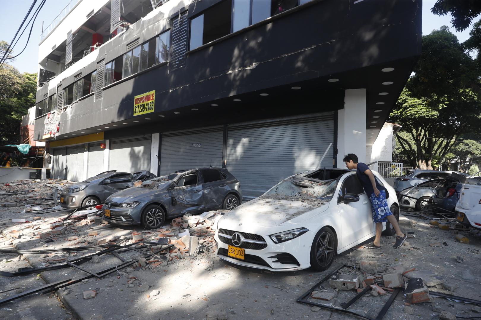 n hombre observa un vehículo afectado tras un fuerte temblor este lunes, en Cali (Colombia)