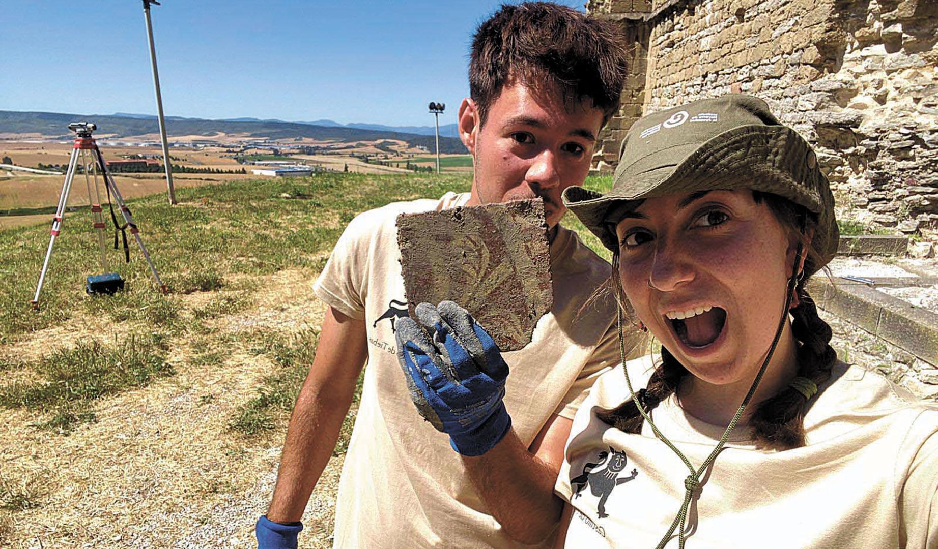 Momento del descubrimiento de uno de los azulejos decorados vidriados, exhumados en la excavación del palacio por Paula Albero y Miguel Apesteguía.
