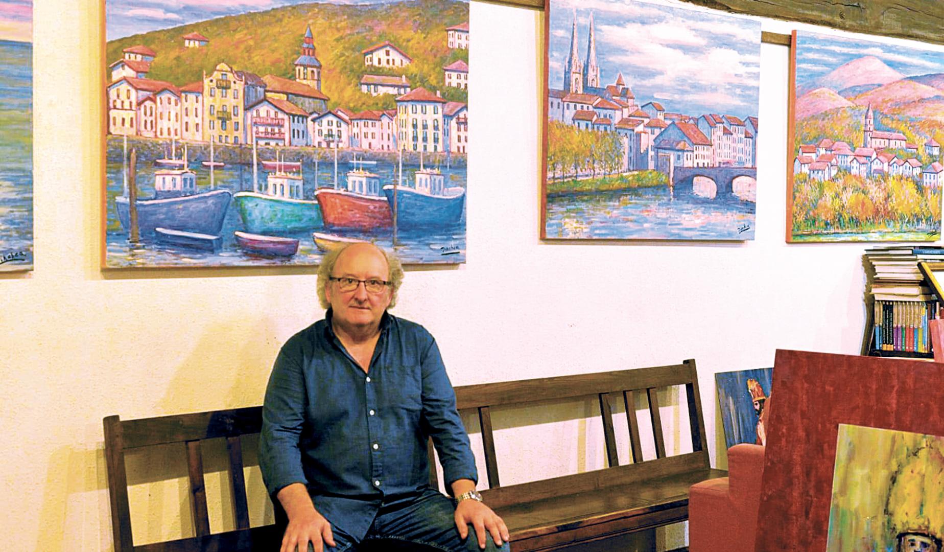 El pintor Juan Carlos PIkabea posando junto a sus cuadros en su casa en Lesaka