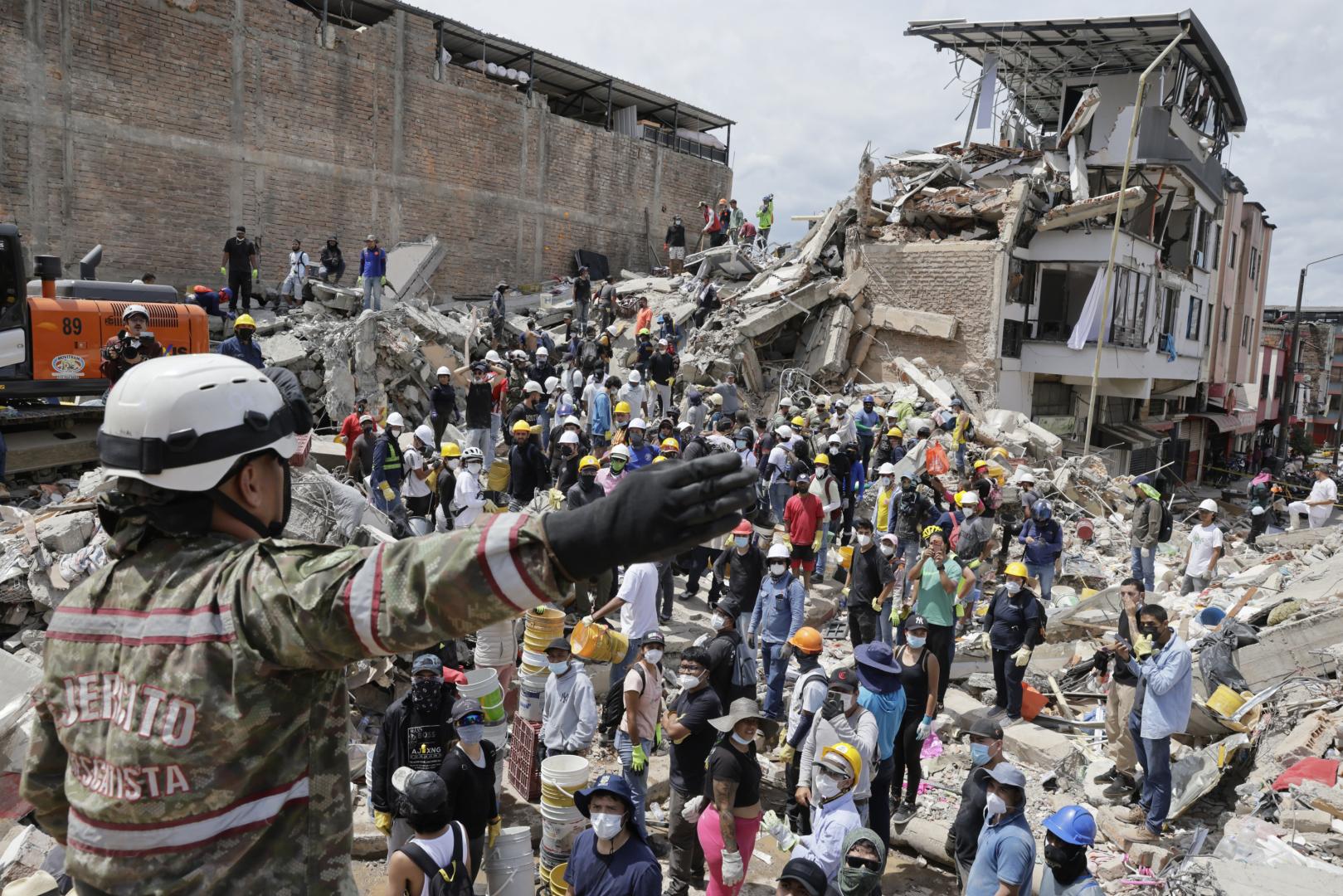 Una rescatista del Ejercito de Colombia da indicaciones a un grupo de voluntarios que realiza labores de búsqueda en edificaciones destruidas por el terremoto de magnitud 7,4 del pasado lunes, este miércoles en Pereira (Colombia)