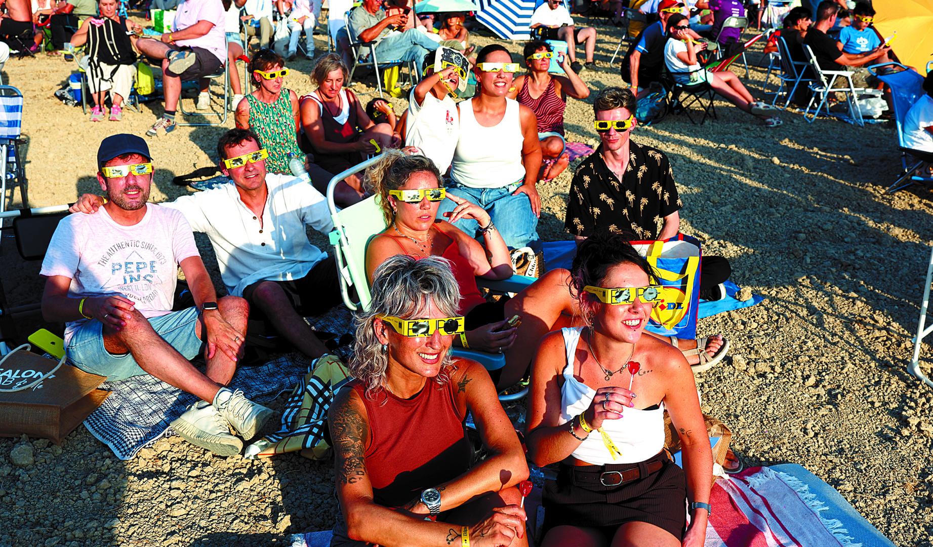 Sentados en sillas o en el suelo, esperando la llegada del eclipse en el antiguo campo de fútbol de La Valdechate de Lerín