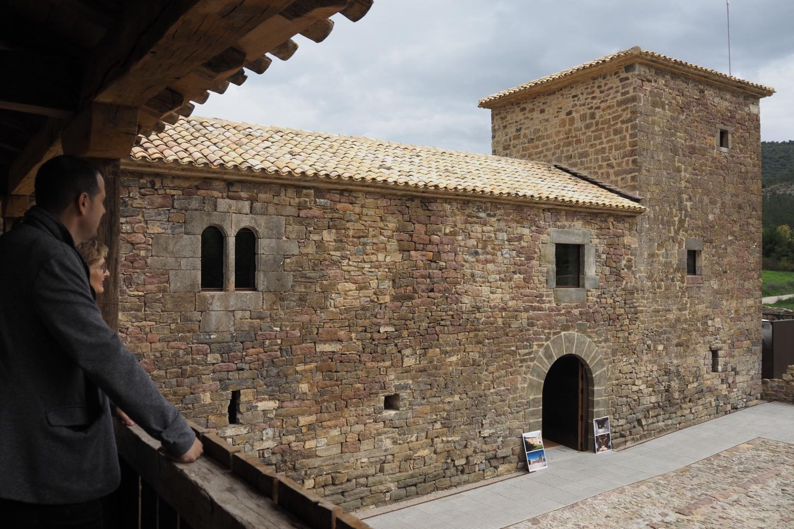 Dos personas contemplan desde un mirador el acceso al Palacio de Arce.