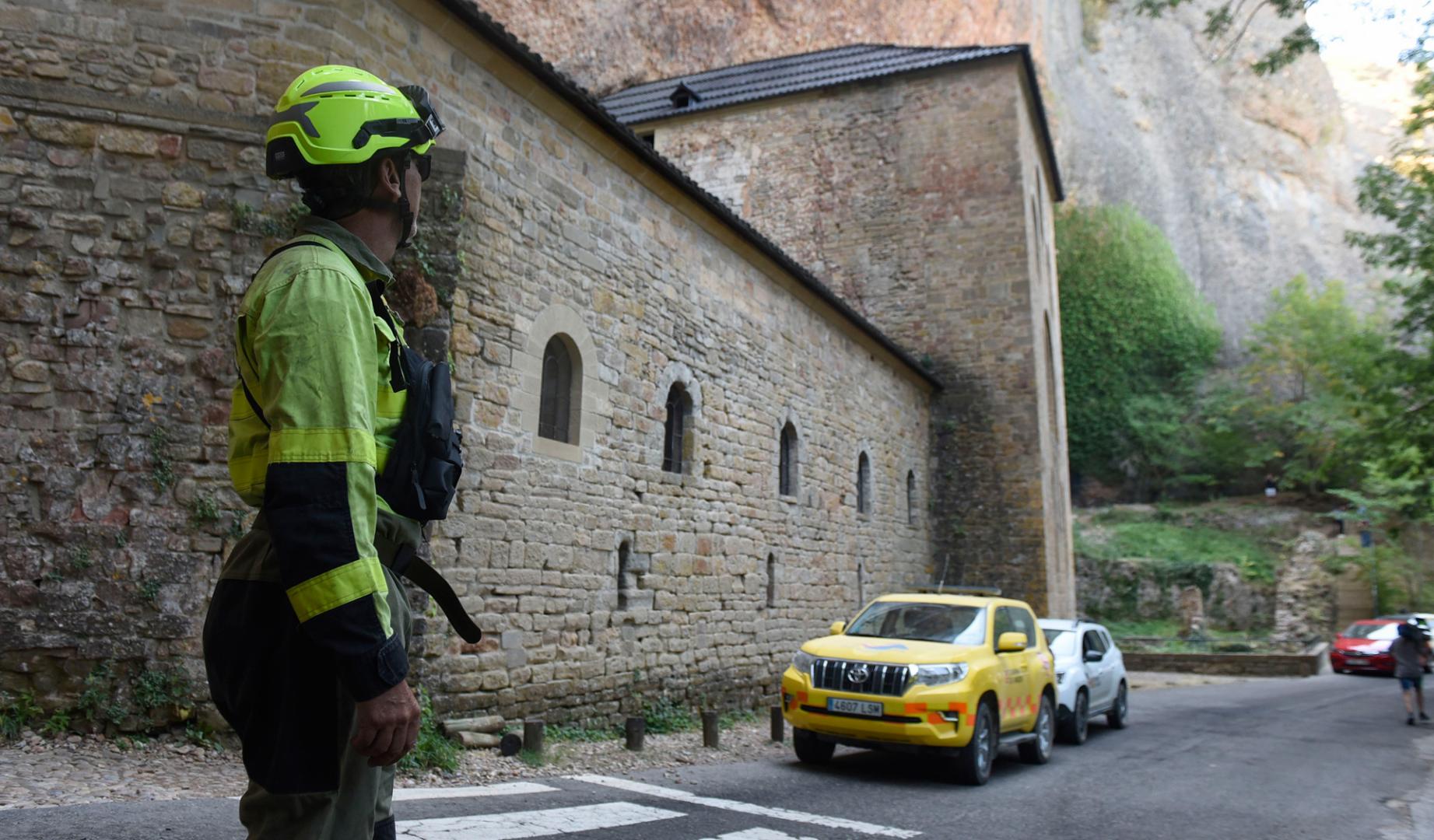 Bomberos trabajan en la extinción del incendio que comenzó en Las Peñas de Riglos, este martes, en la zona de los monasterios nuevo y viejo de San Juan de La Peña