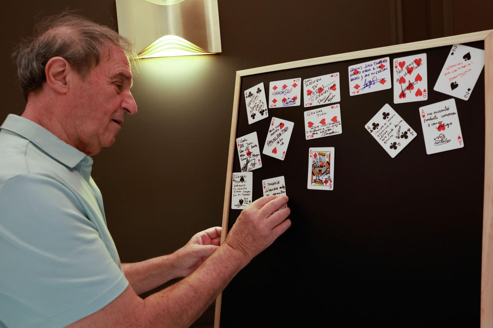 Un hombre deja una nota en una cartas de la baraja en recuerdo y agradecimiento del mago Juan Tamariz