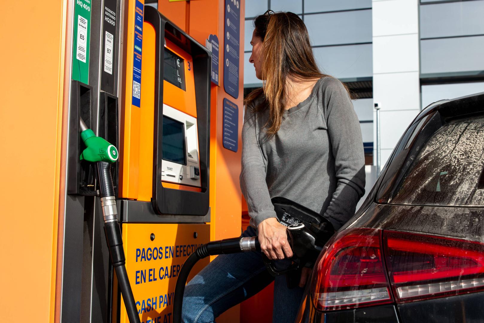 Una conductora reposta diésel en una gasolinera
