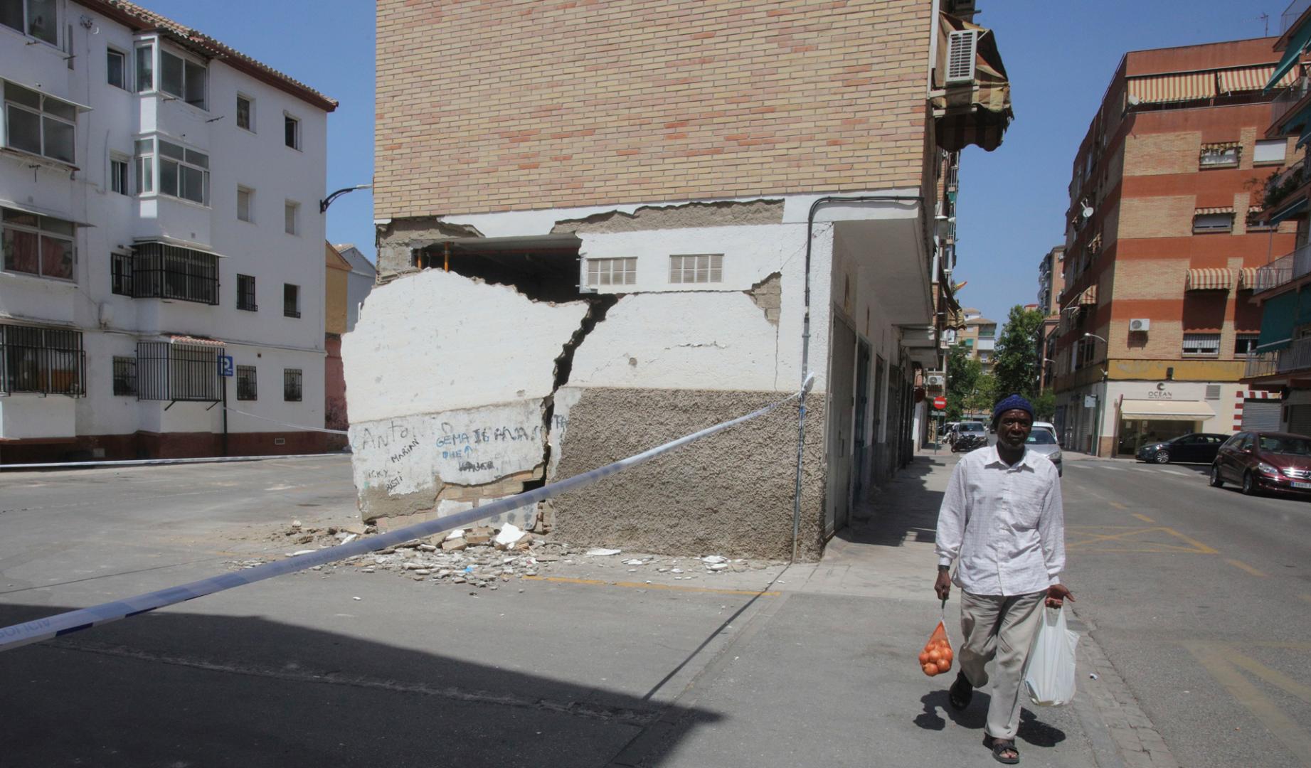 Un hombre pasa este jueves junto a una vivienda con desperfectos causados por los terremotos de los días anteriores en Granada