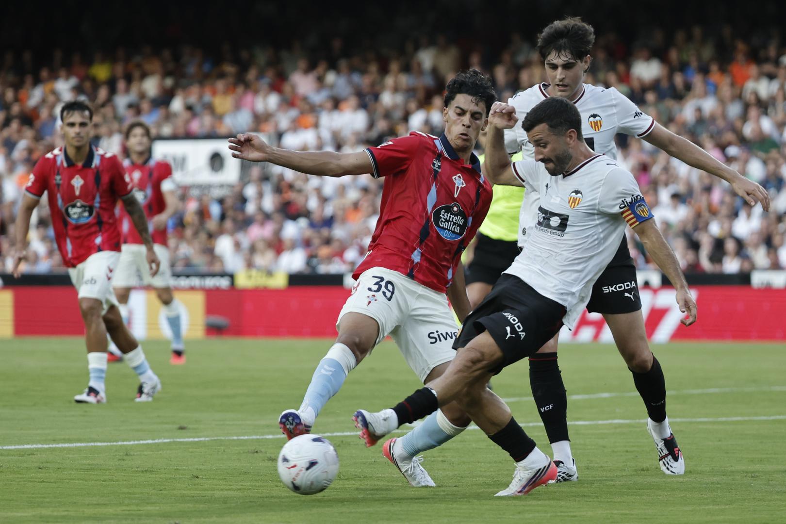 El defensa del Valencia José Luis Gayá pelea un balón con Jones El Abdellaoui, del Celta