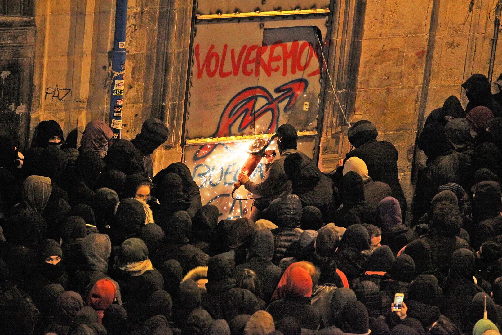 Los radicales, la noche del 19 de enero de 2019, tratando de cortar con una radial las chapas metálicas con las que se cerraron los accesos al Palacio de Rozalejo