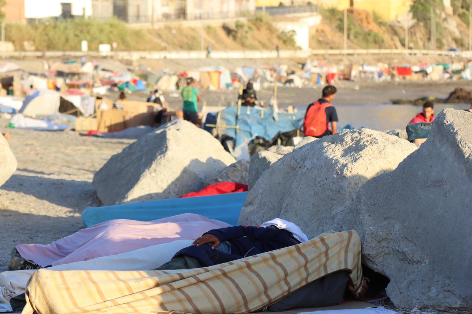 Migrantes acampan en la playa de El Trampolín, en Ceuta, este jueves