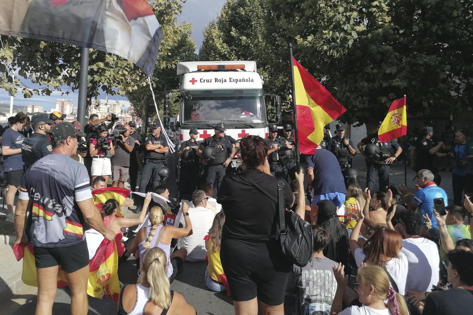 Sentada con la que una concentración de unos 50 ceutis han bloqueado el paso de un convoy de Cruz Roja que iba a dar comida a los inmigrantes que permanecen en la Playa del Trampolín de Ceuta