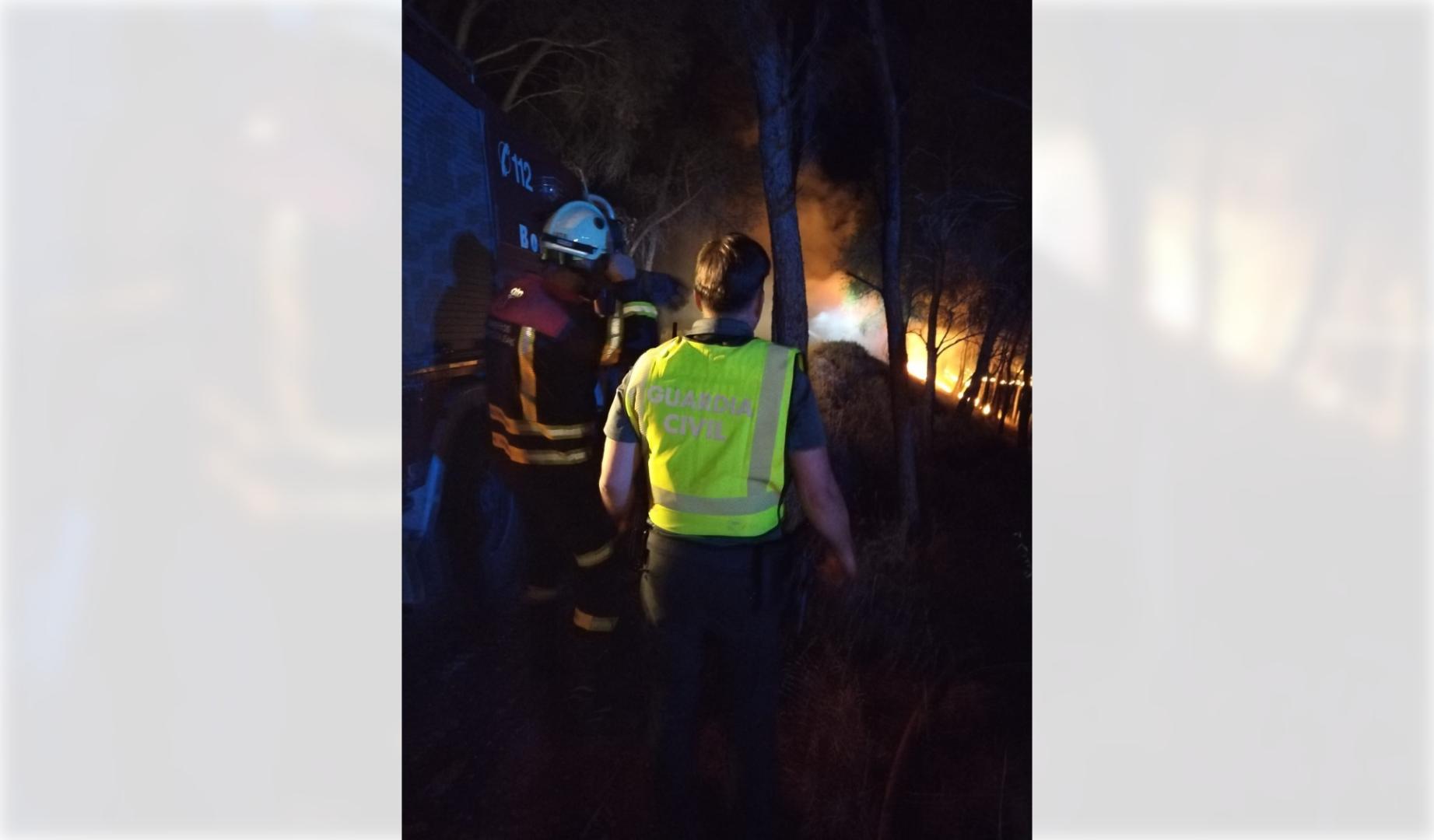 Imagen de un agente de la Guardia Civil y bomberos, en el incendio de Peralta