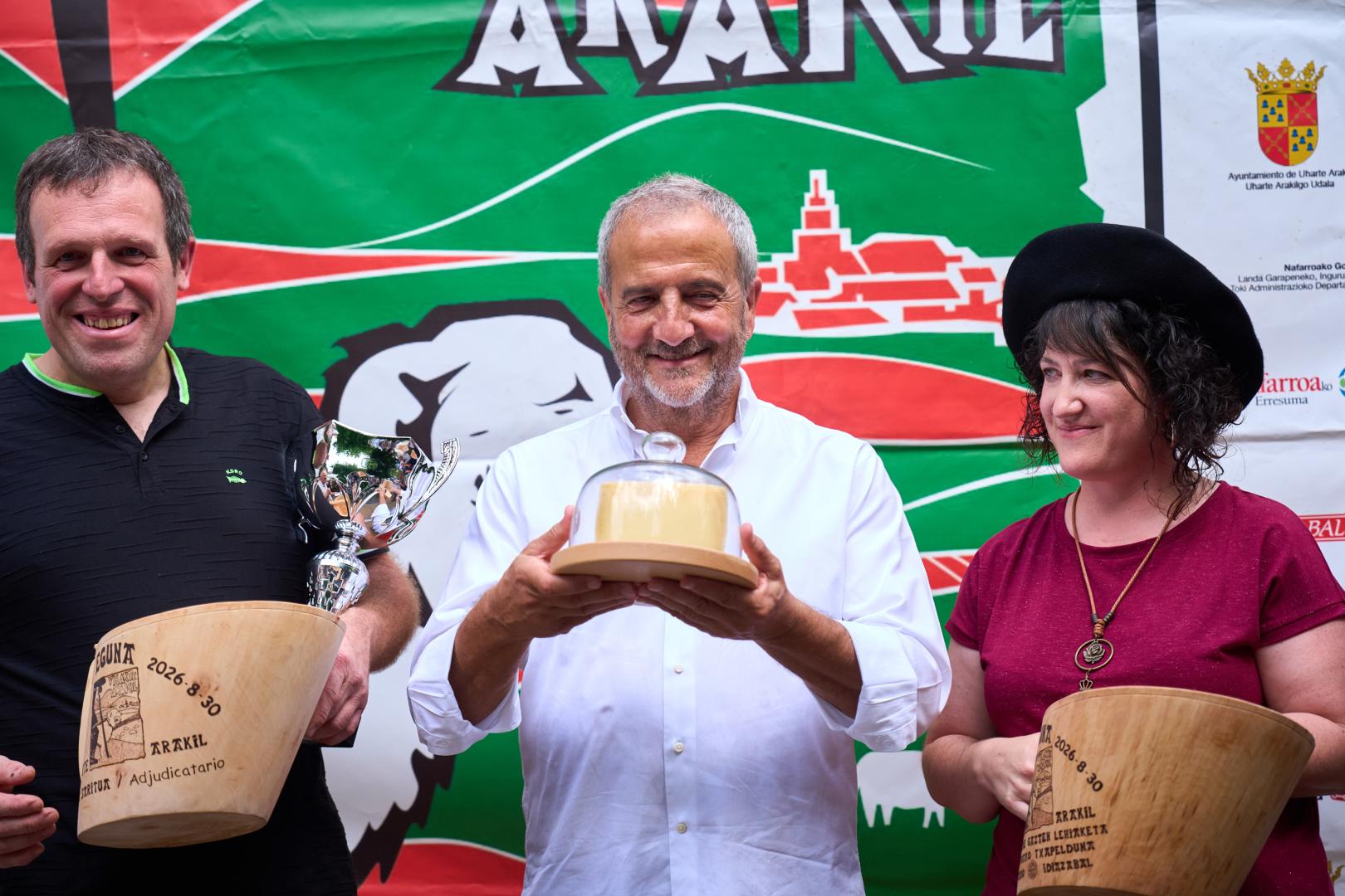 Enirque Martínez, del restaurante Maher, sujeta el queso ganador entre los representantes de la quesería Loperena, ganadores del concurso.