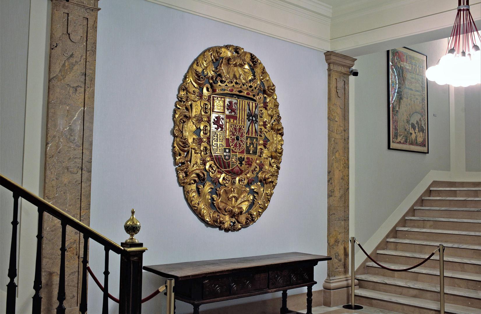 El escudo de armas reales, tallado en madera en 1735, en el zaguán de la casa consistorial de Pamplona