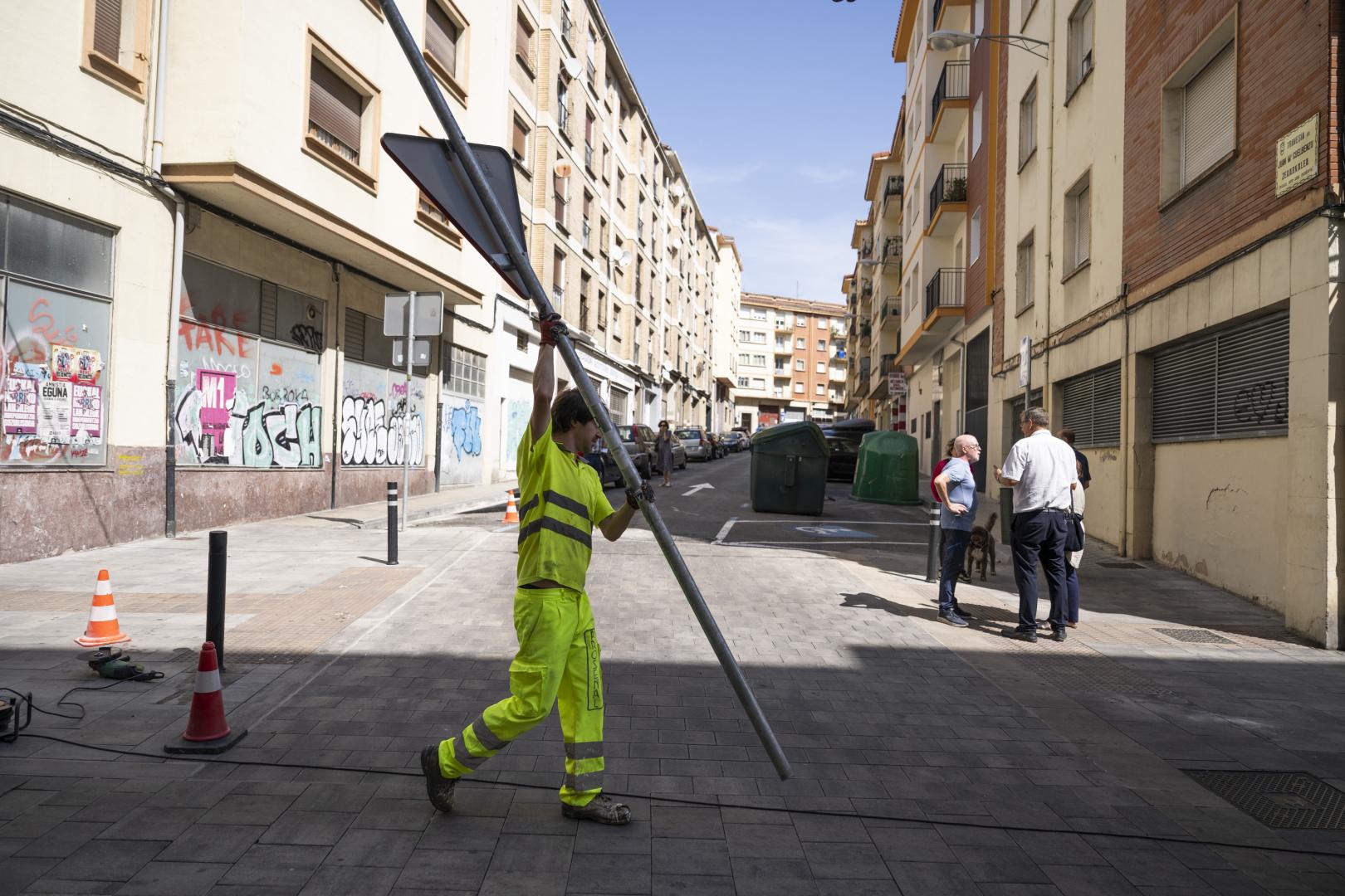 Un operario traslada una señal de ‘ceda el paso’ en la zona de acceso limitado de la calle Manuel de Falla