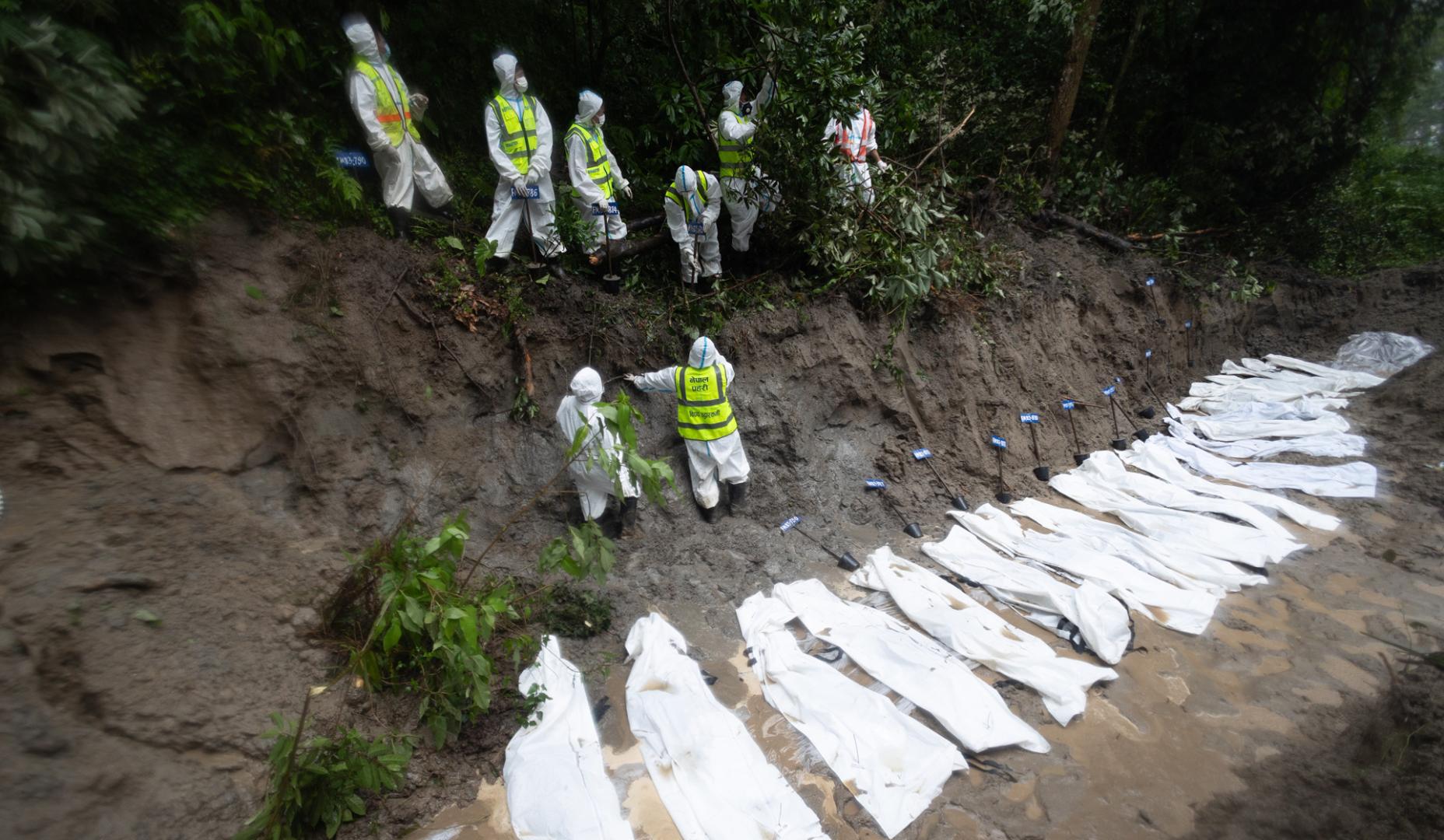 Agentes de cuerpos de emergencias junto a varios cadáveres sin identificar en Nepal