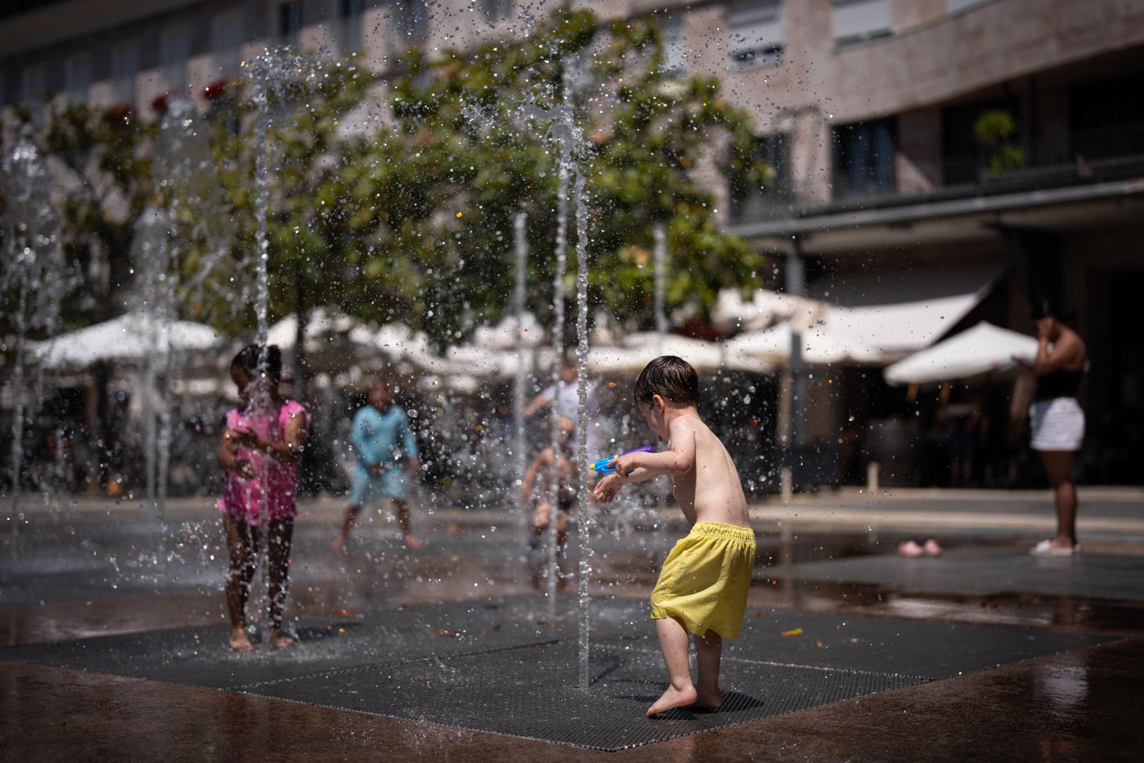 Varios niños se refrescan en la plaza de Yamaguchi el pasado 24 de mayo, cuando se alcanzaron los 32,3° en Pamplona