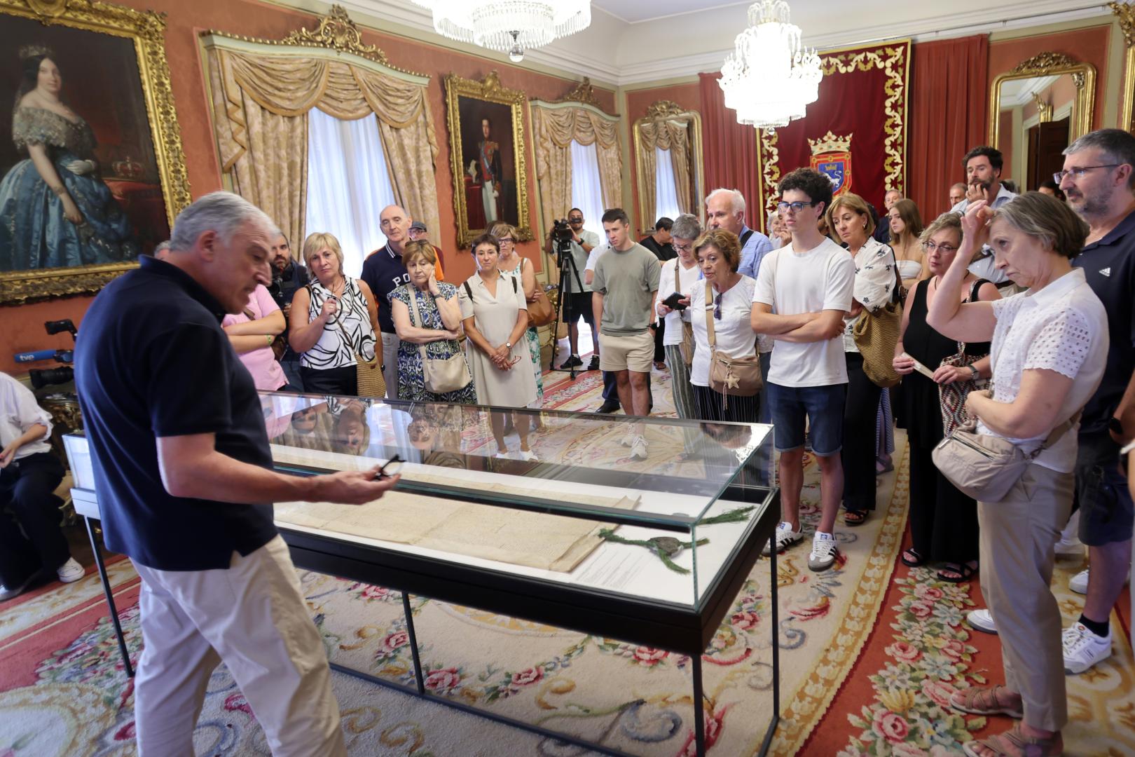 El alcalde Asiron, junto a la vitrina en la que se conserva el original del siglo XV del Privilegio de la Unión, durante la visita al consistorio