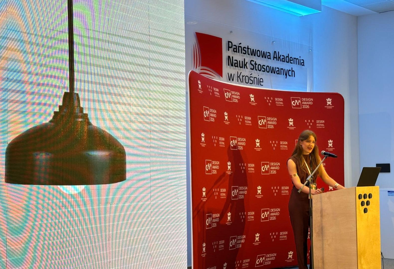 Ana Andueza, junto a un ejemplar de la lámpara que ha diseñado, interviene en el certamen que se celebró en Polonia