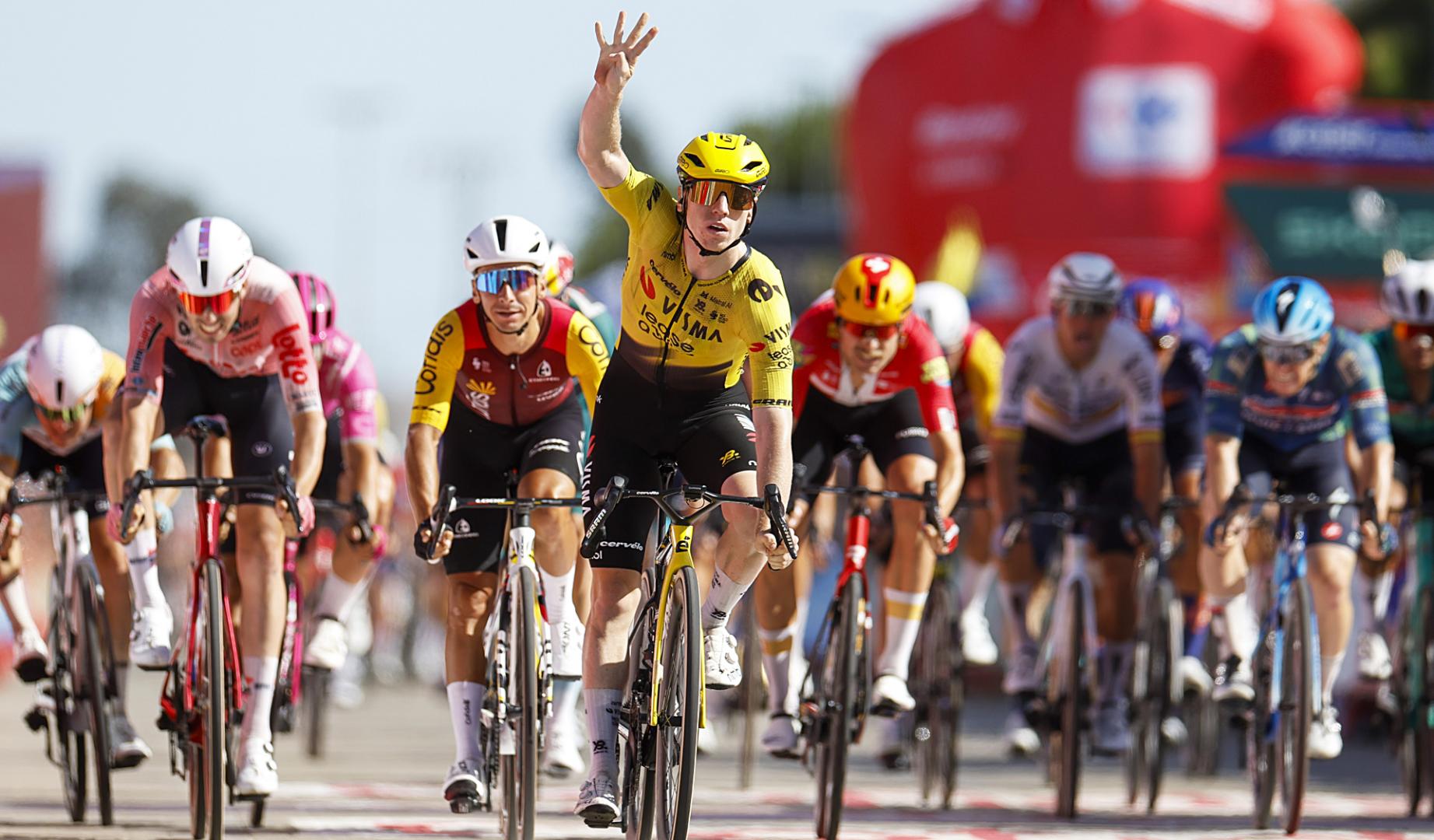 El británico del Visma Lease a Bike Matthew Brennan cruza la meta de Palos de la Frontera señalando su cuarta victoria en La Vuelta 2026
