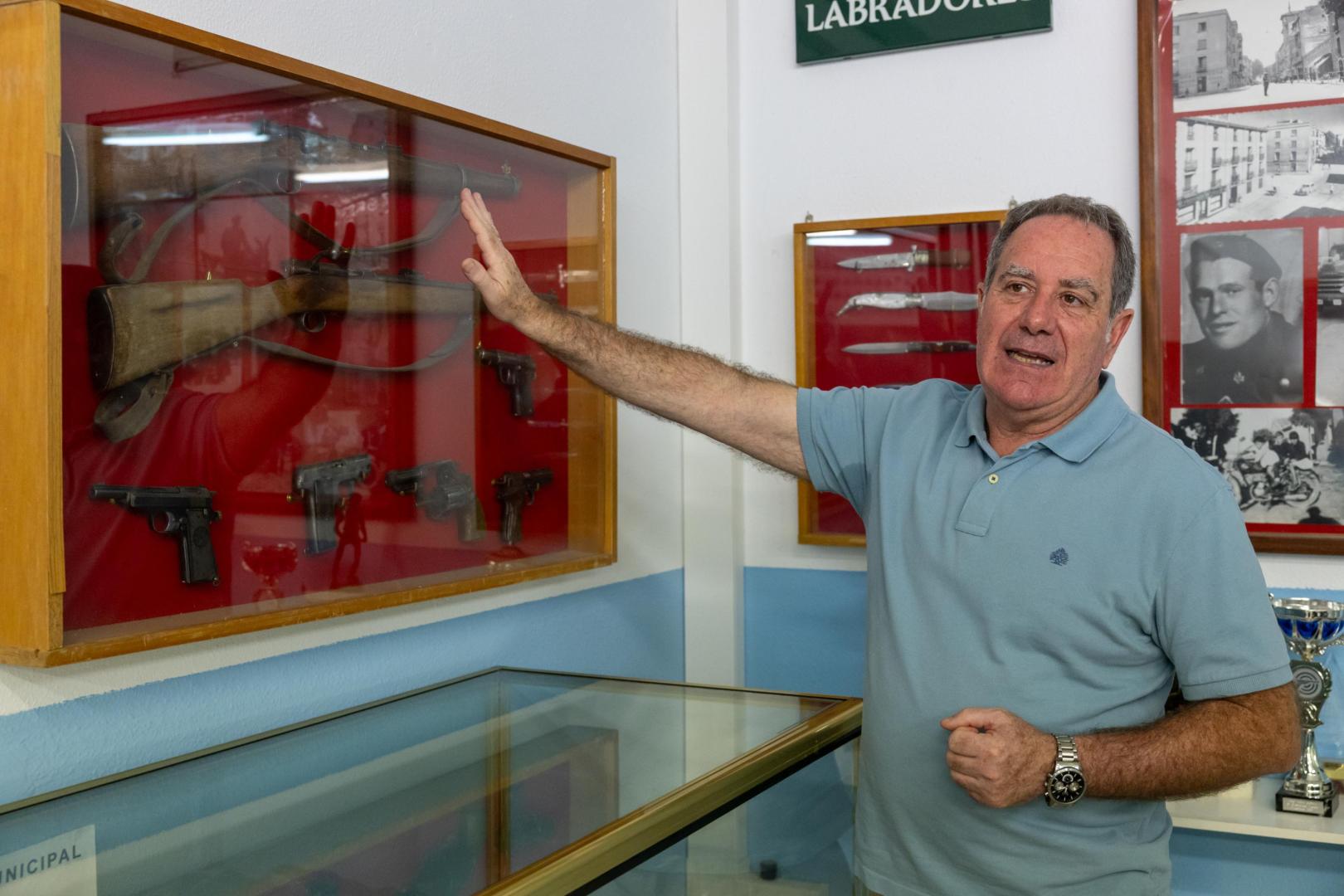 Alberto Buñuel junto a unas escopetas guardadas en una vitrina elaborada con sus propias manos
