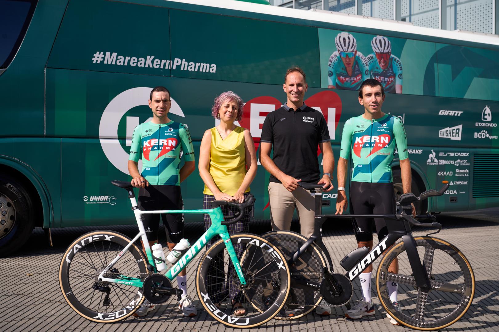 Ibon Ruiz y Diego Uriarte flanquean a la consejera de Deporte Rebeca Esnaola y el mánager general del equipo Juanjo Oroz, ante el autobús y las bicicletas que utilizarán en la Vuelta a España.