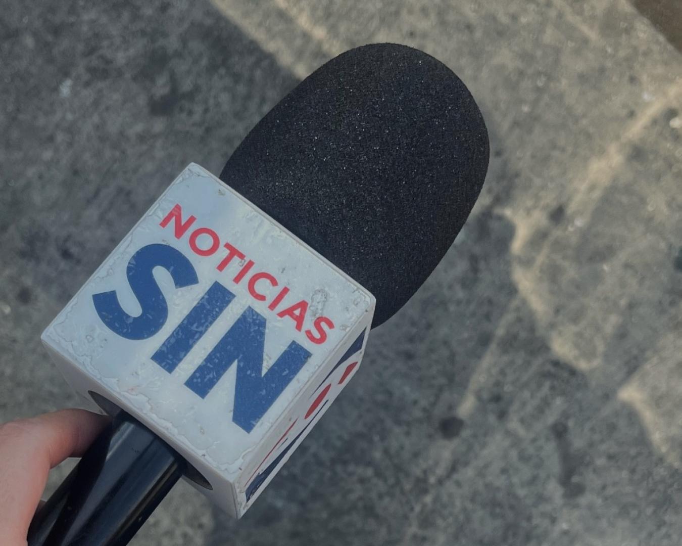 Noelia Gabás sujeta el micrófono del medio en el que trabaja, Noticias SIN