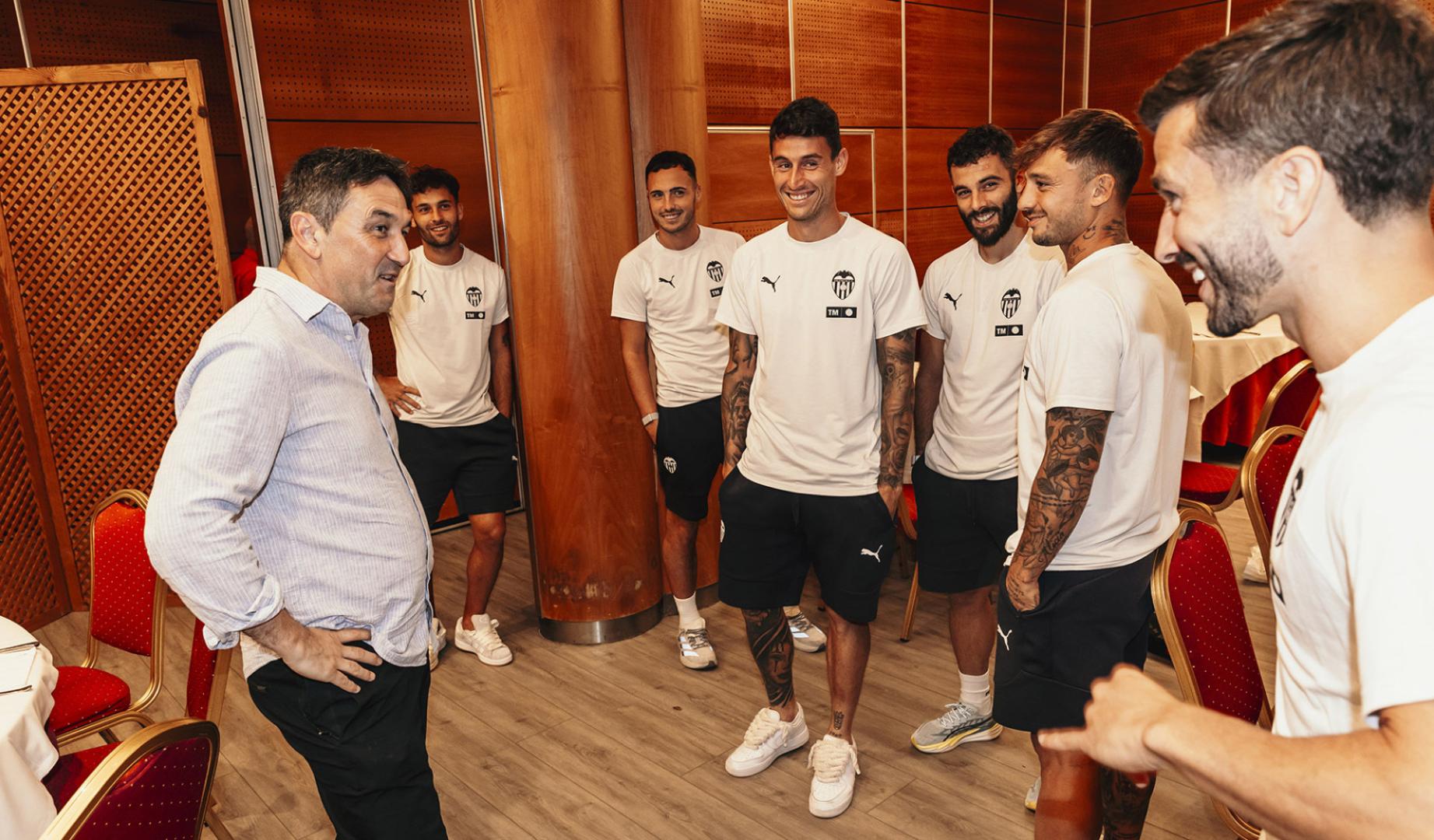 Braulio Vázquez saluda a los futbolistas del Valencia en Vitoria