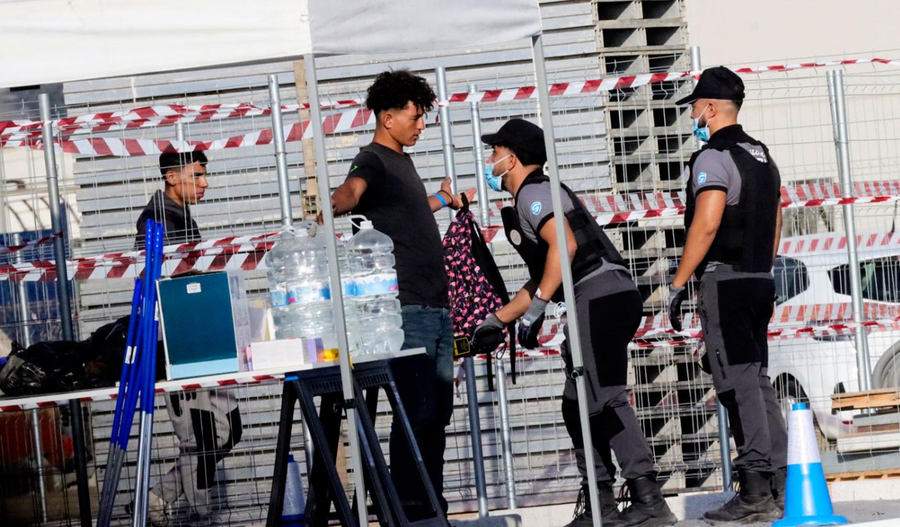 Inmigrantes acceden por el control y registro para de acceder al campamento temporal en muelle Poniente del puerto de Ceuta,