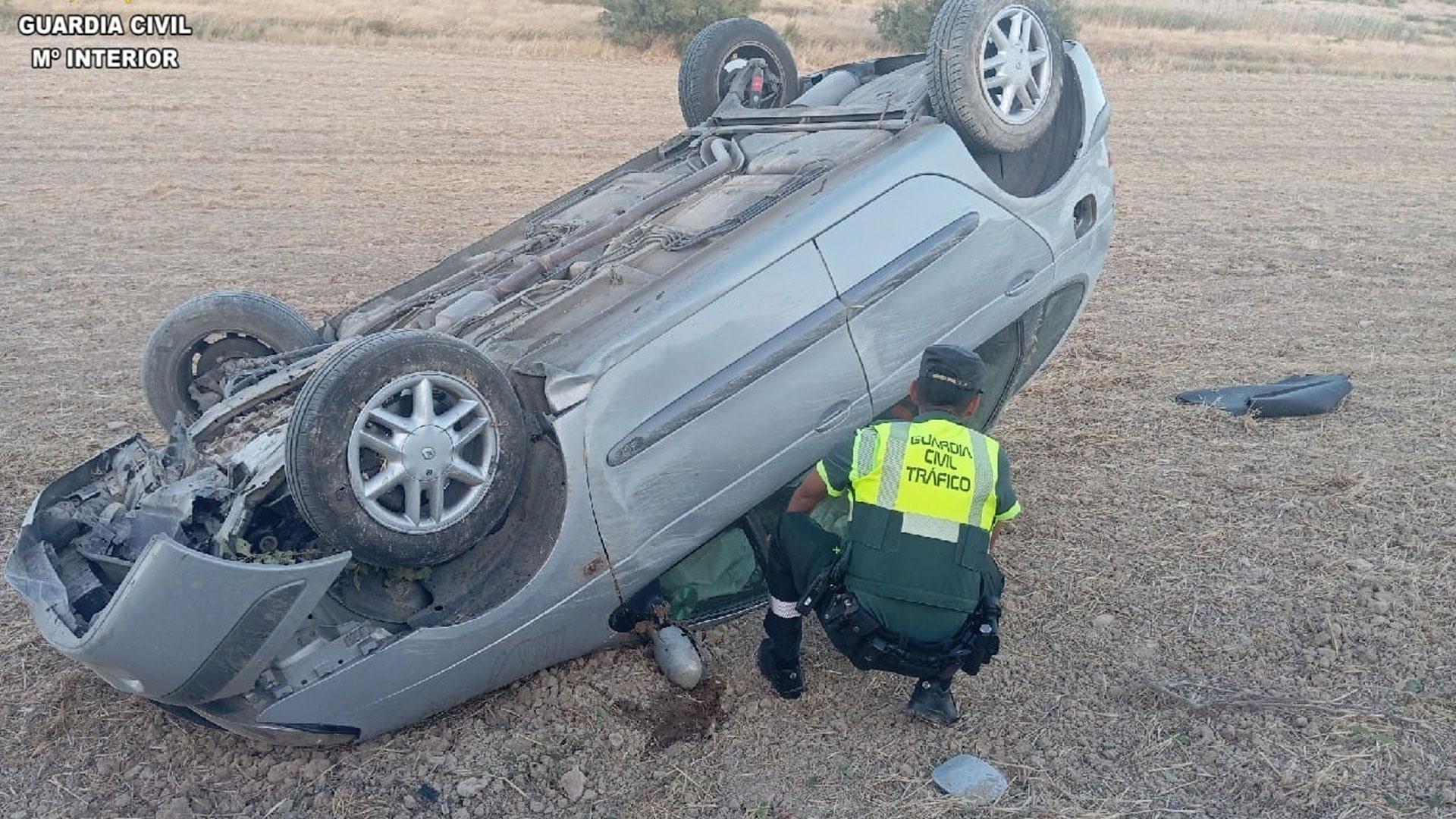 Un agente de la Guardia Civil revisa el estado del vehículo que ha volcado en Olite