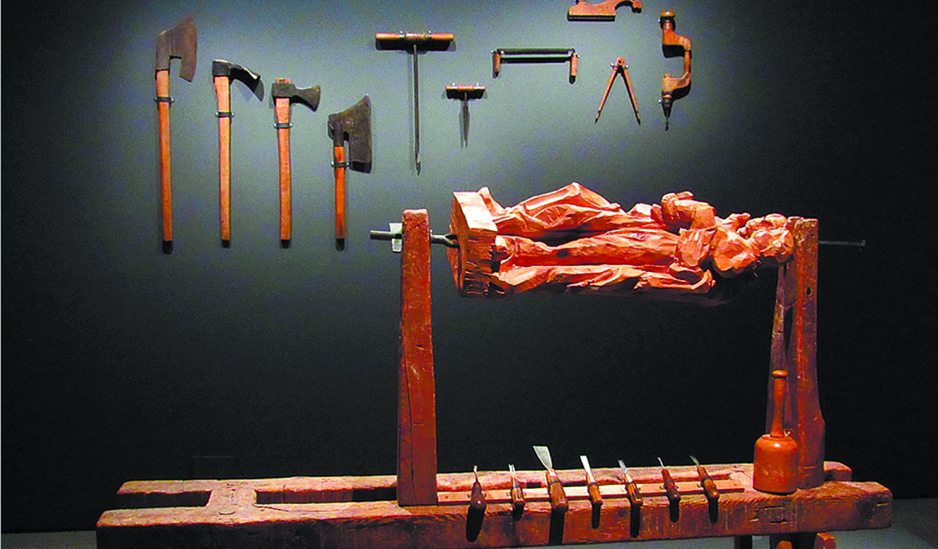 Arriba, e taller de un escultor, en recreación del Museo Nacional de Escultura de Valladolid, en 2016. Debajo, escultura de San Eloy, patrono del gremio de los plateros, fines del siglo XVI, en la sacristía de San Saturnino de Pamplona