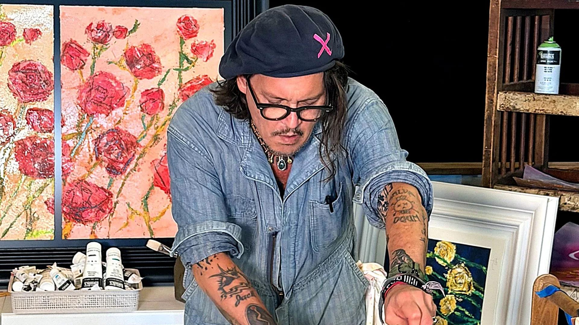 Johnny Depp con algunas de sus pinturas